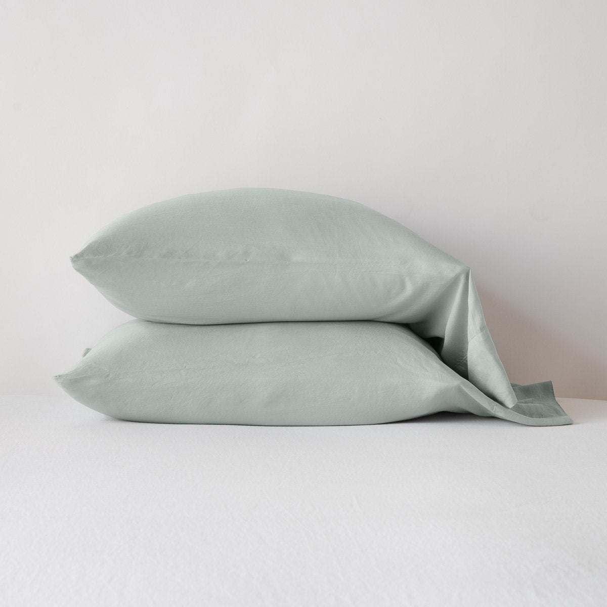 : Madera Luxe sleeping pillows in eucalyptus, stacked neatly against a white backdrop - side view.