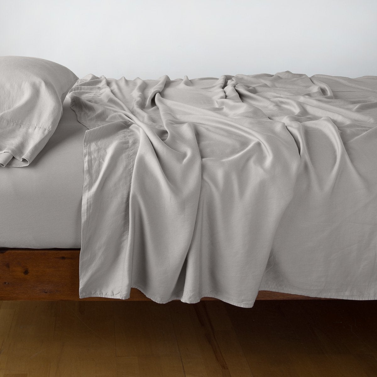 Fog: sleeping pillow with matching rumpled sheeting - side view.