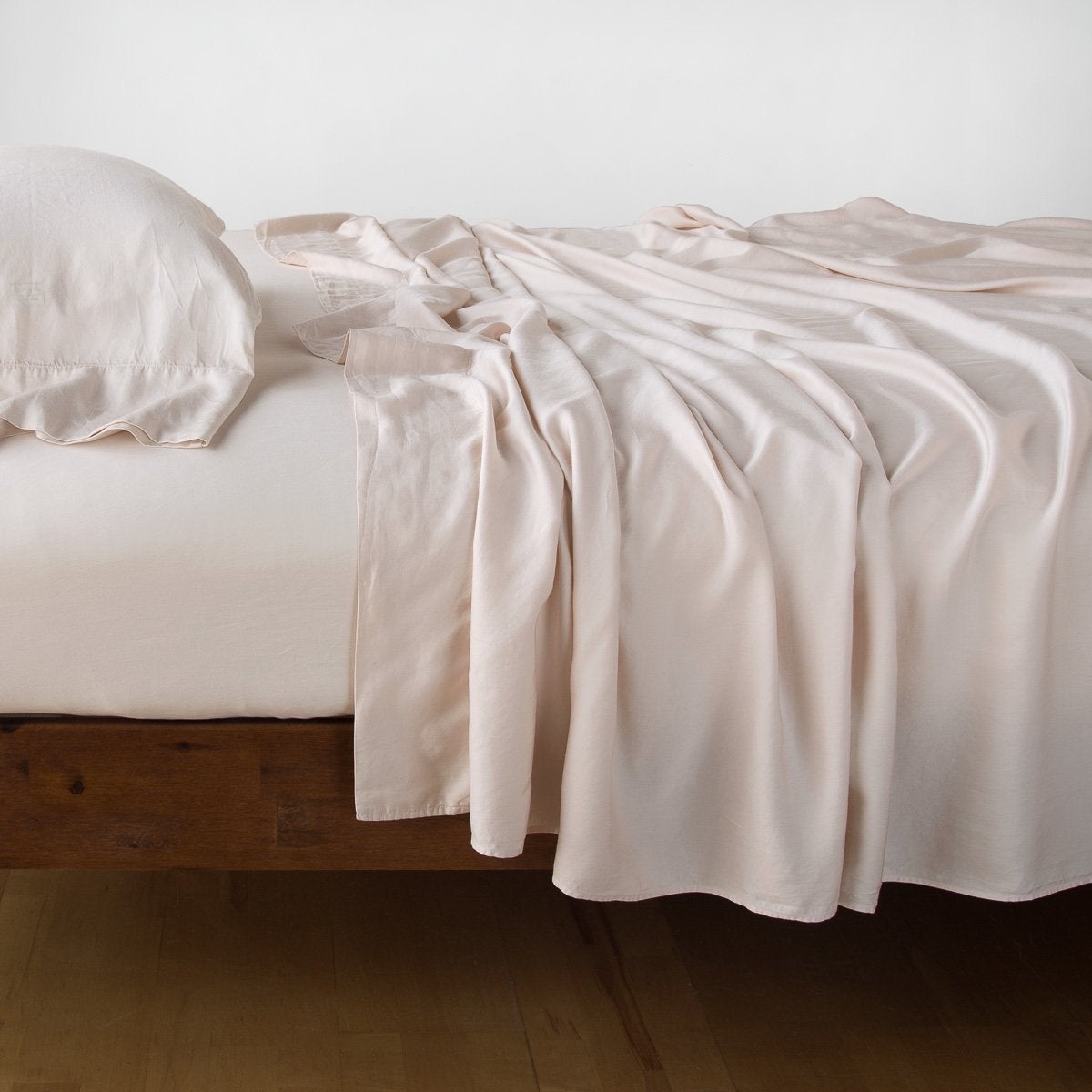Pearl: sleeping pillow with matching rumpled sheeting - side view.
