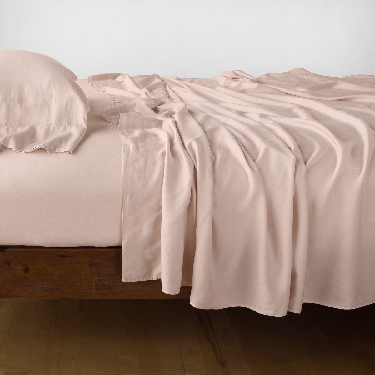 Rouge: sleeping pillow with matching rumpled sheeting - side view.