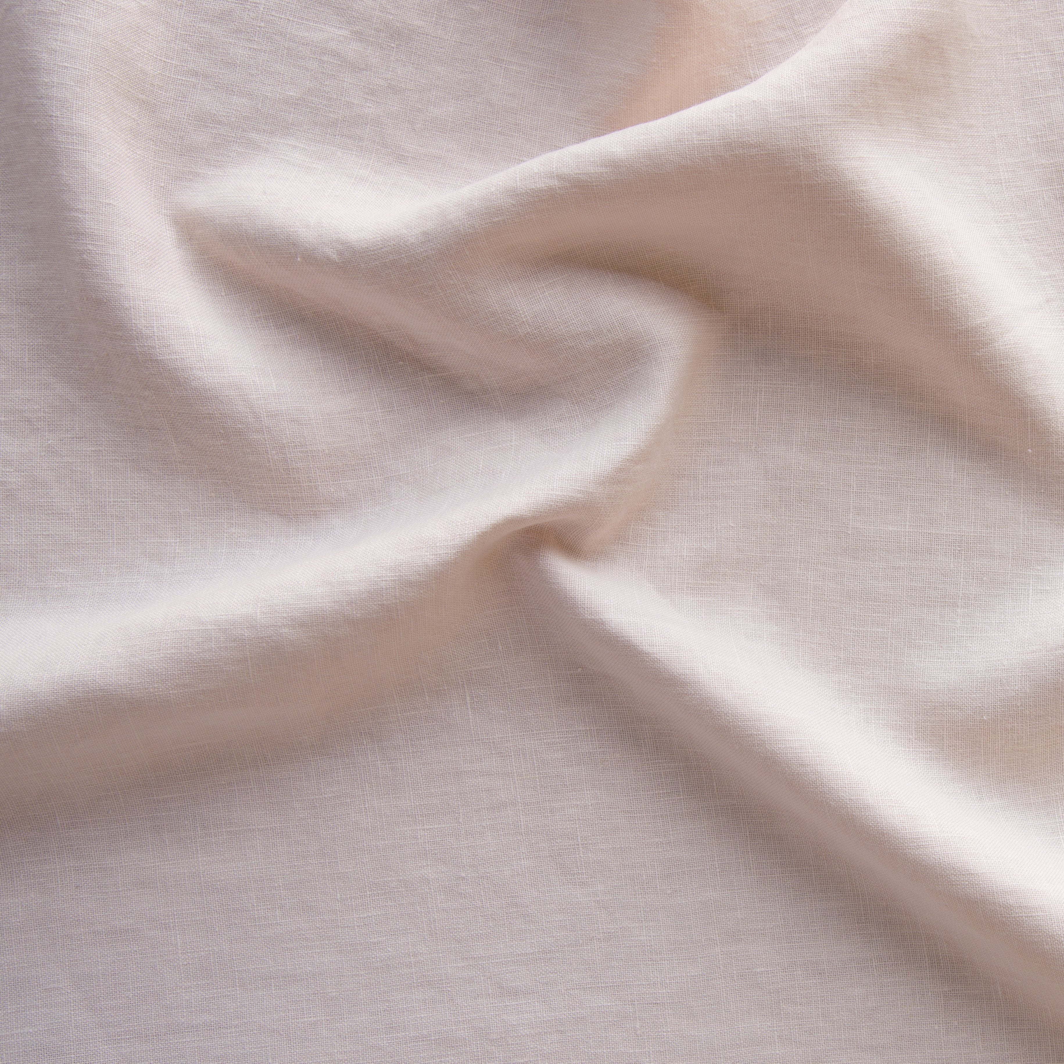 Pearl: A close up of midweight linen in pearl, a nude-like, soft rose pink tone.
