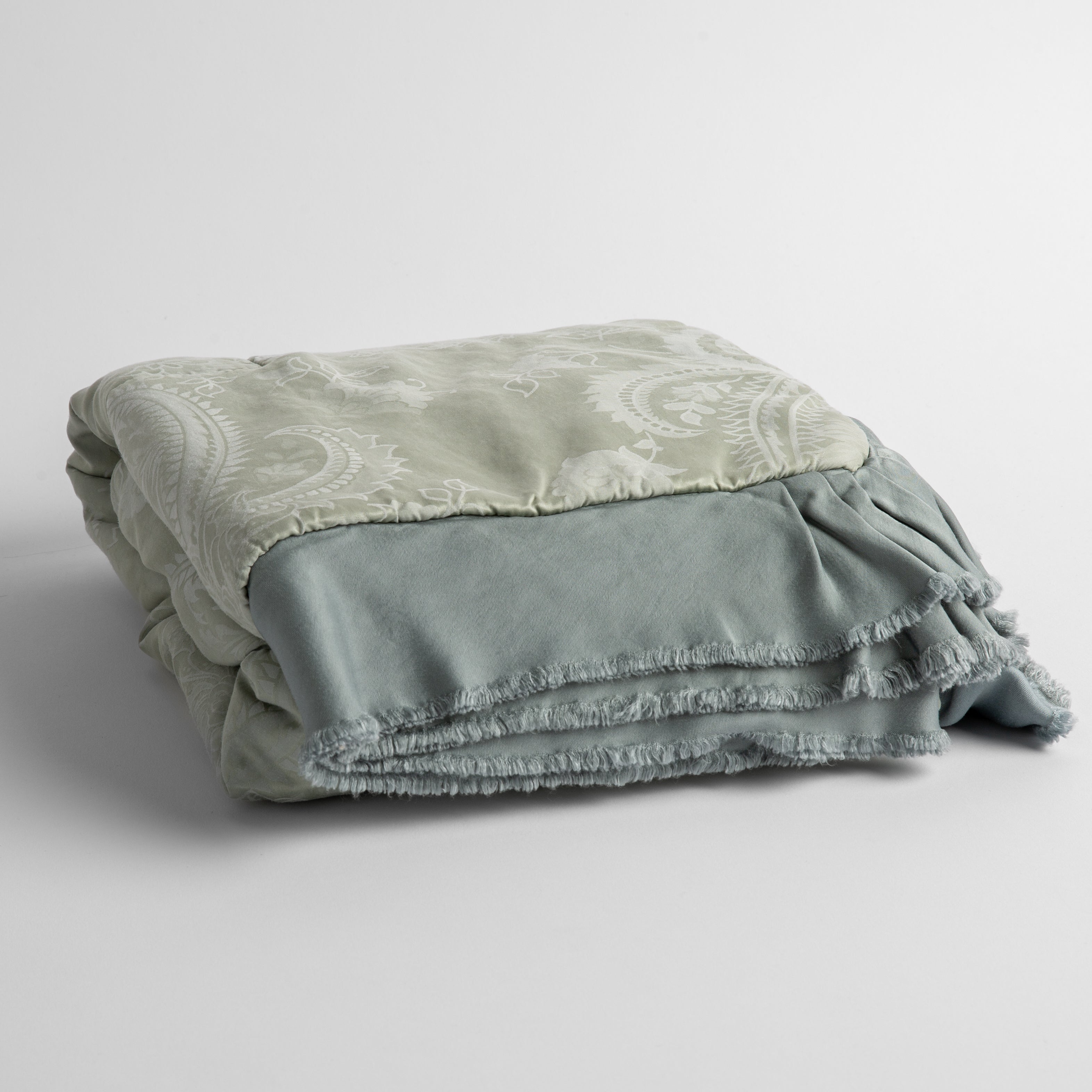 Mineral: a silk and tencel™ jacquard baby blanket folded and shot against a white background with the ruffled trim situated to be visible