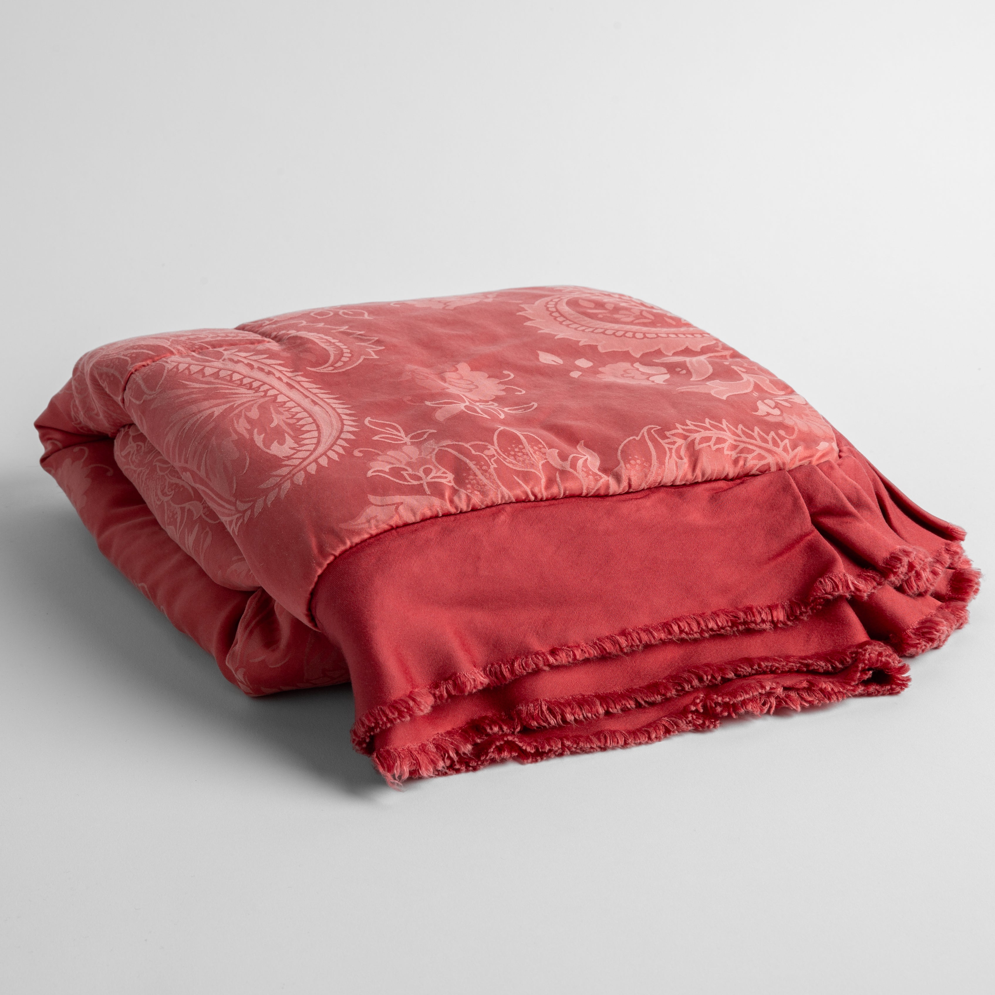 Poppy: a silk and tencel™ jacquard baby blanket folded and shot against a white background with the ruffled trim situated to be visible