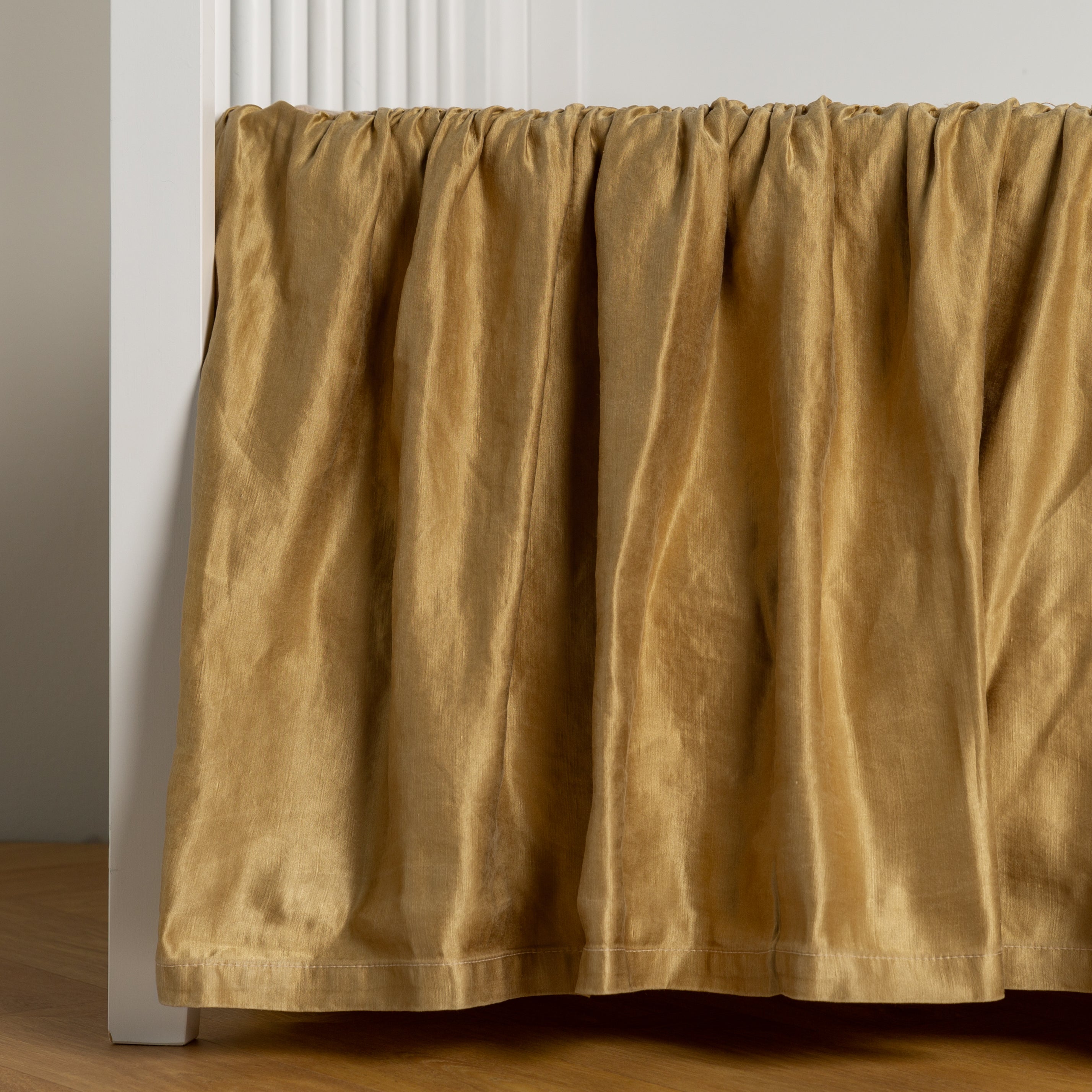 Honeycomb: charmeuse crib skirt shown on a white crib against a white wall and medium wood floor.