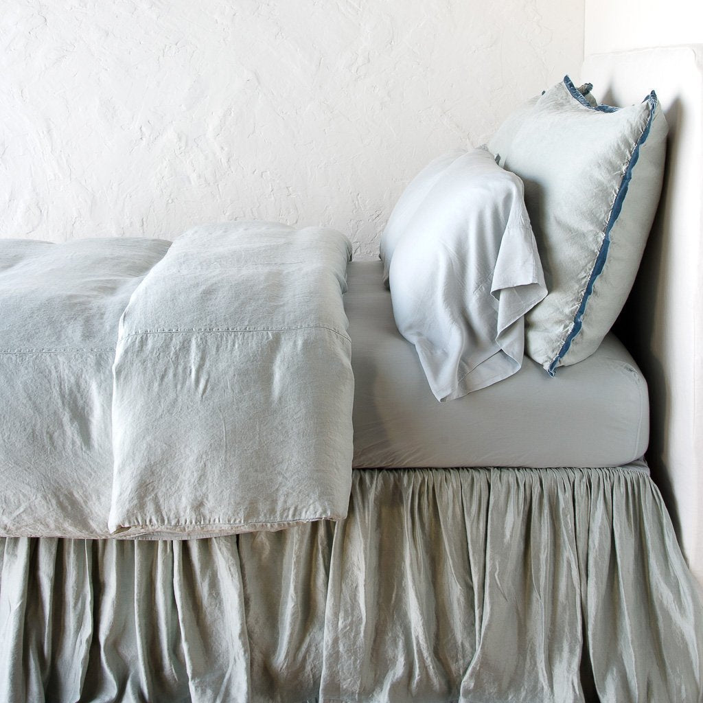 : Paloma duvet cover with matching pillows and bed skirt - mineral, side view.