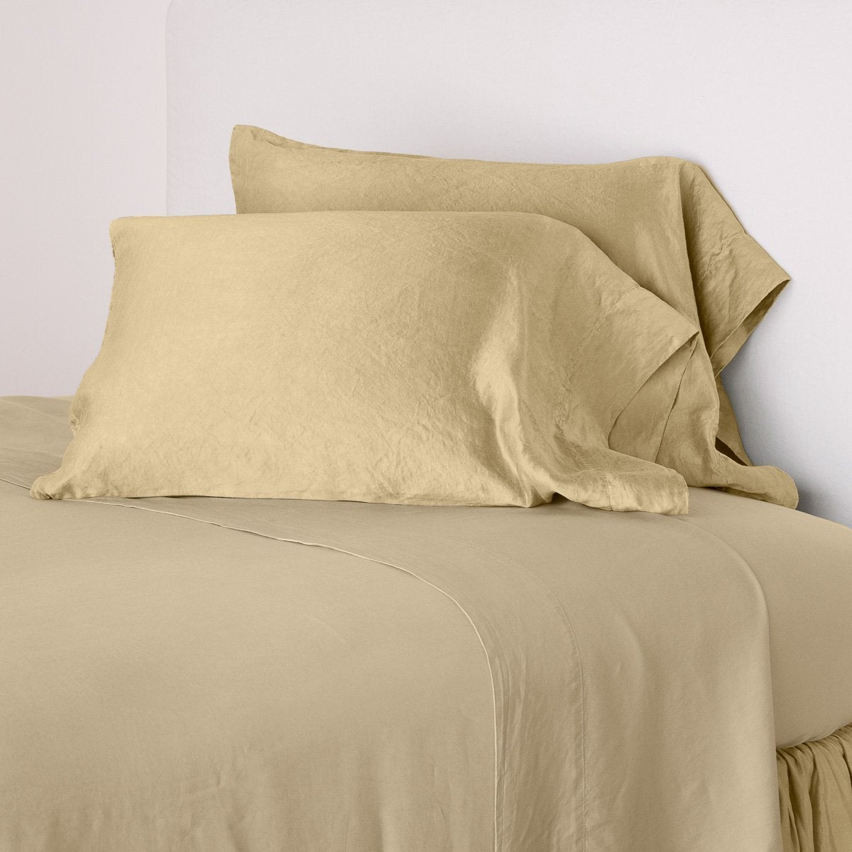 Honeycomb: sleeping pillows leaning upright against a white wall on monochromatic sheeting - cropped three-quarter angle.