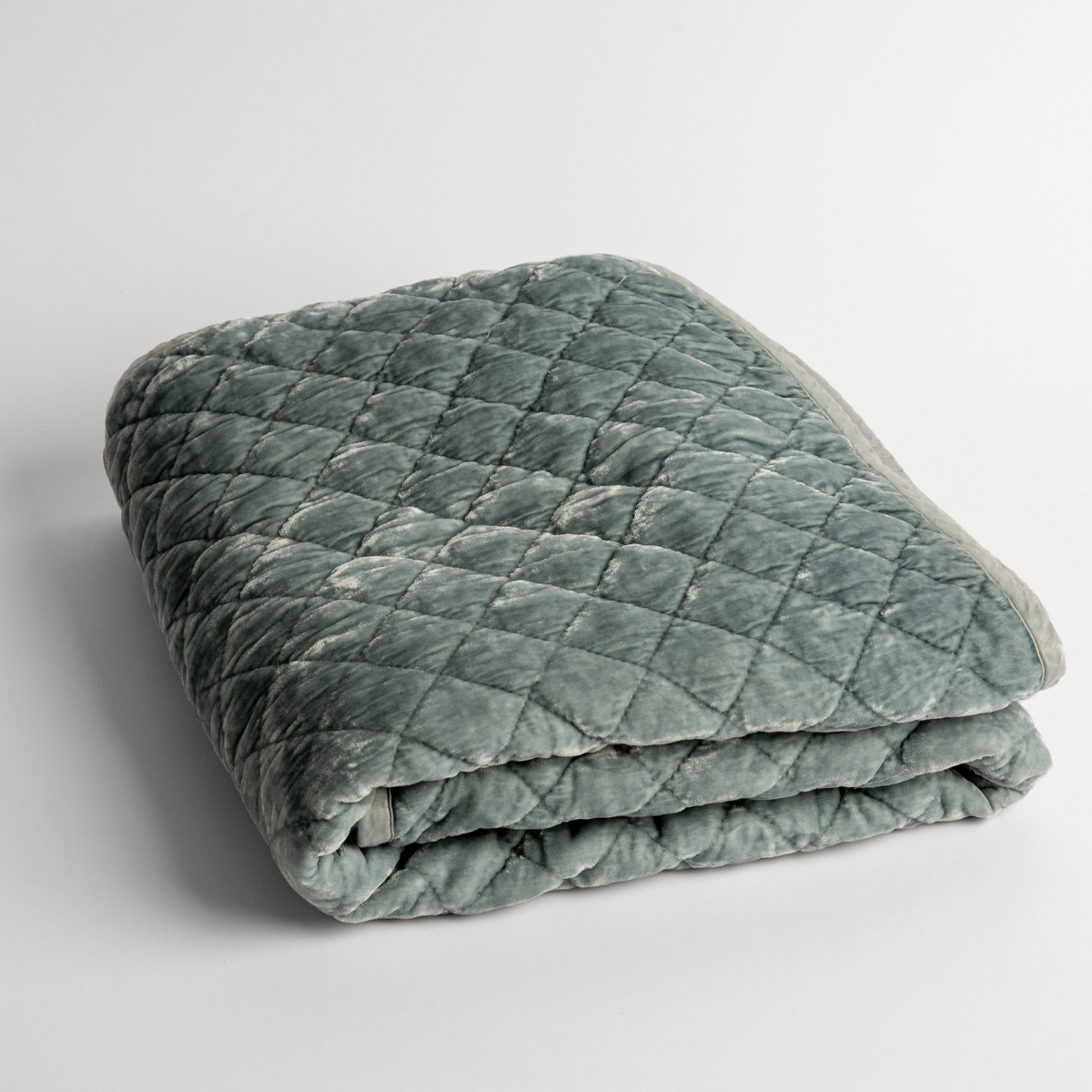 Cloud: a folded quilted silk velvet baby blanket shown from overhead to showcase quilting pattern and texture.