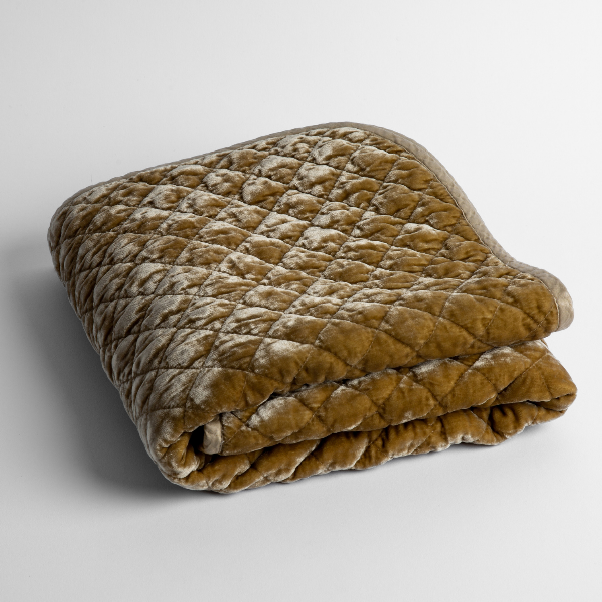 Honeycomb: a folded quilted silk velvet baby blanket shown from overhead to showcase quilting pattern and texture.
