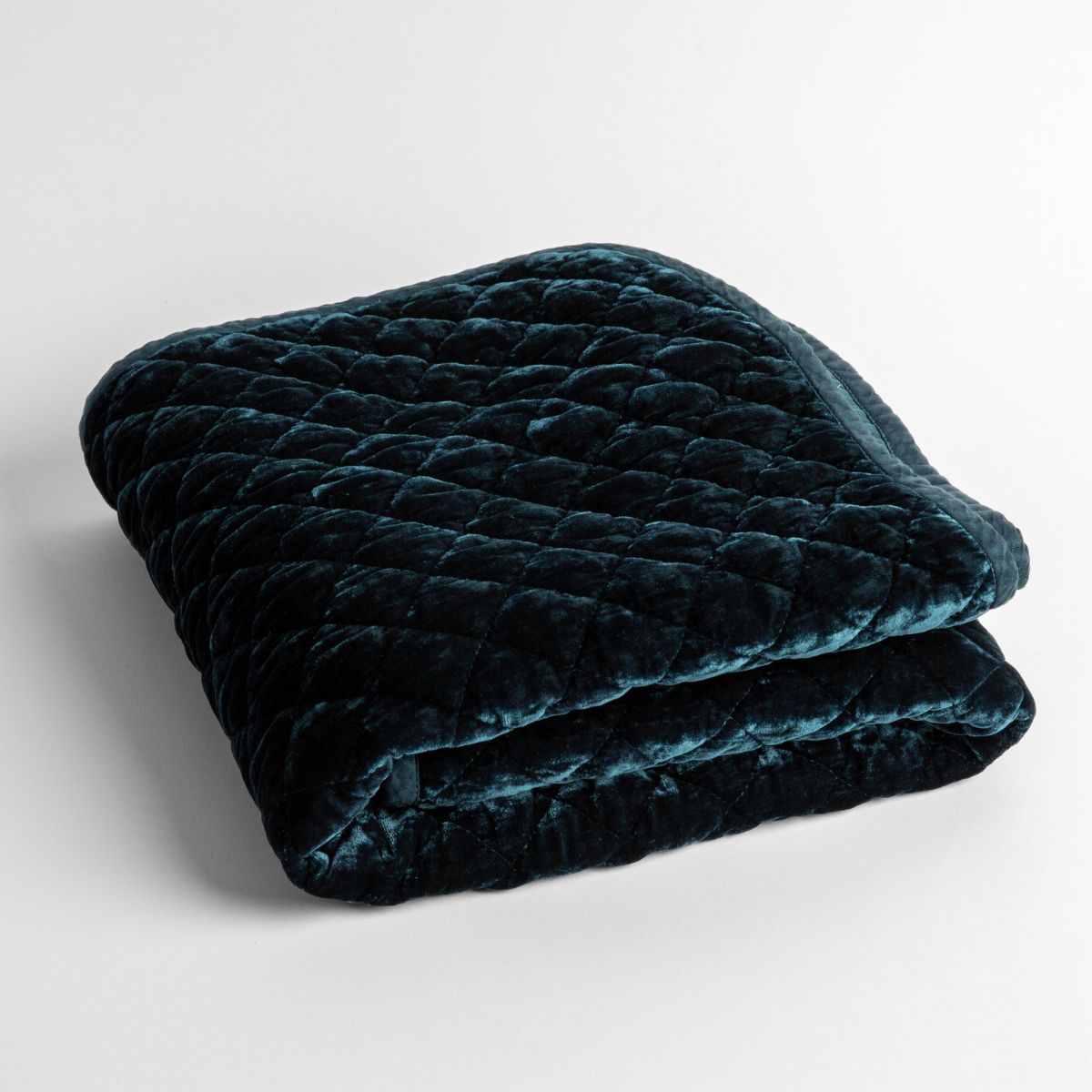 Midnight: a folded quilted silk velvet baby blanket shown from overhead to showcase quilting pattern and texture.