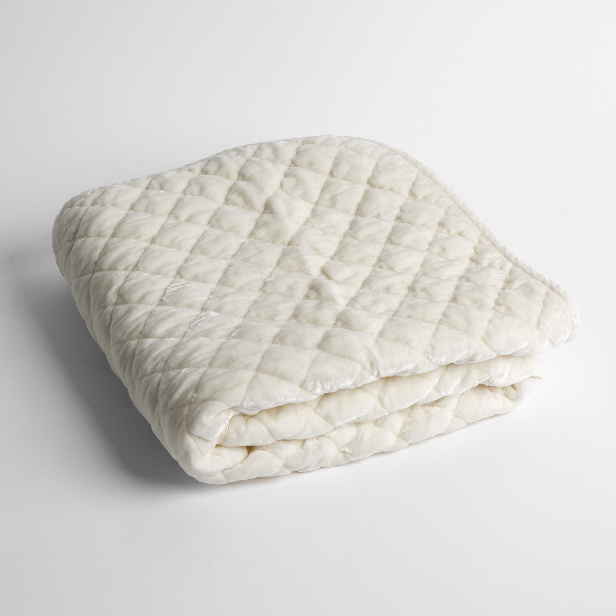 Winter White: a folded quilted silk velvet baby blanket shown from overhead to showcase quilting pattern and texture.