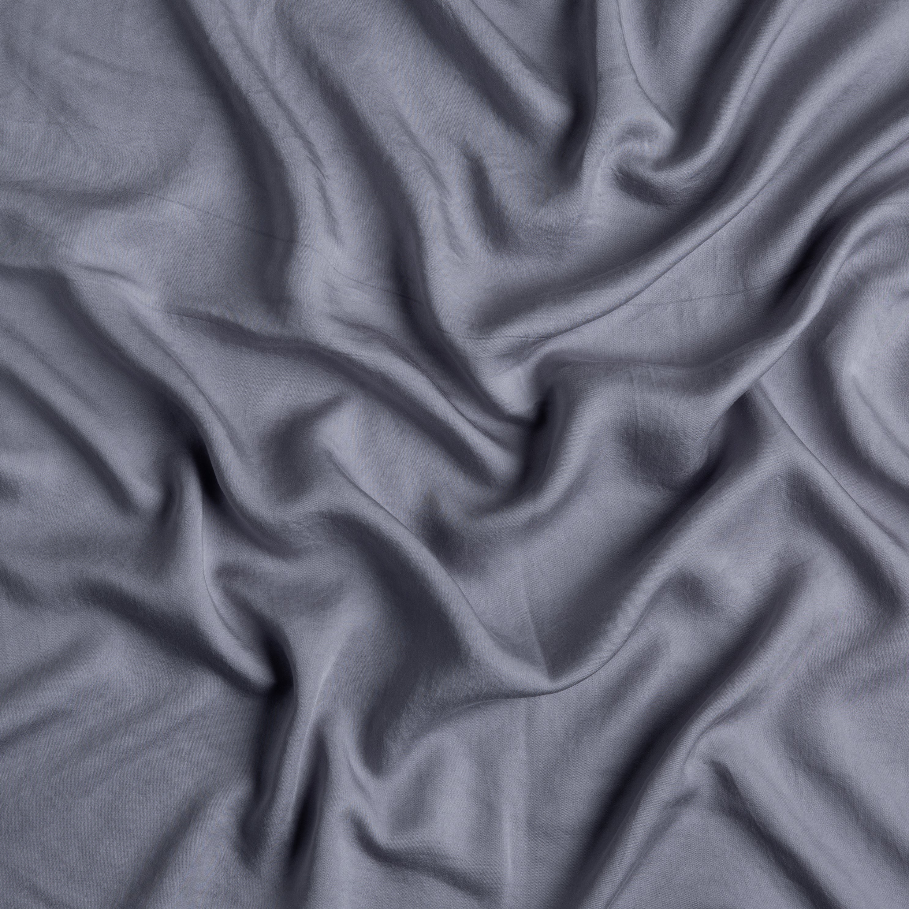 a close up of tencel fabric gently rumpled and in french lavender, a pale purple tone.