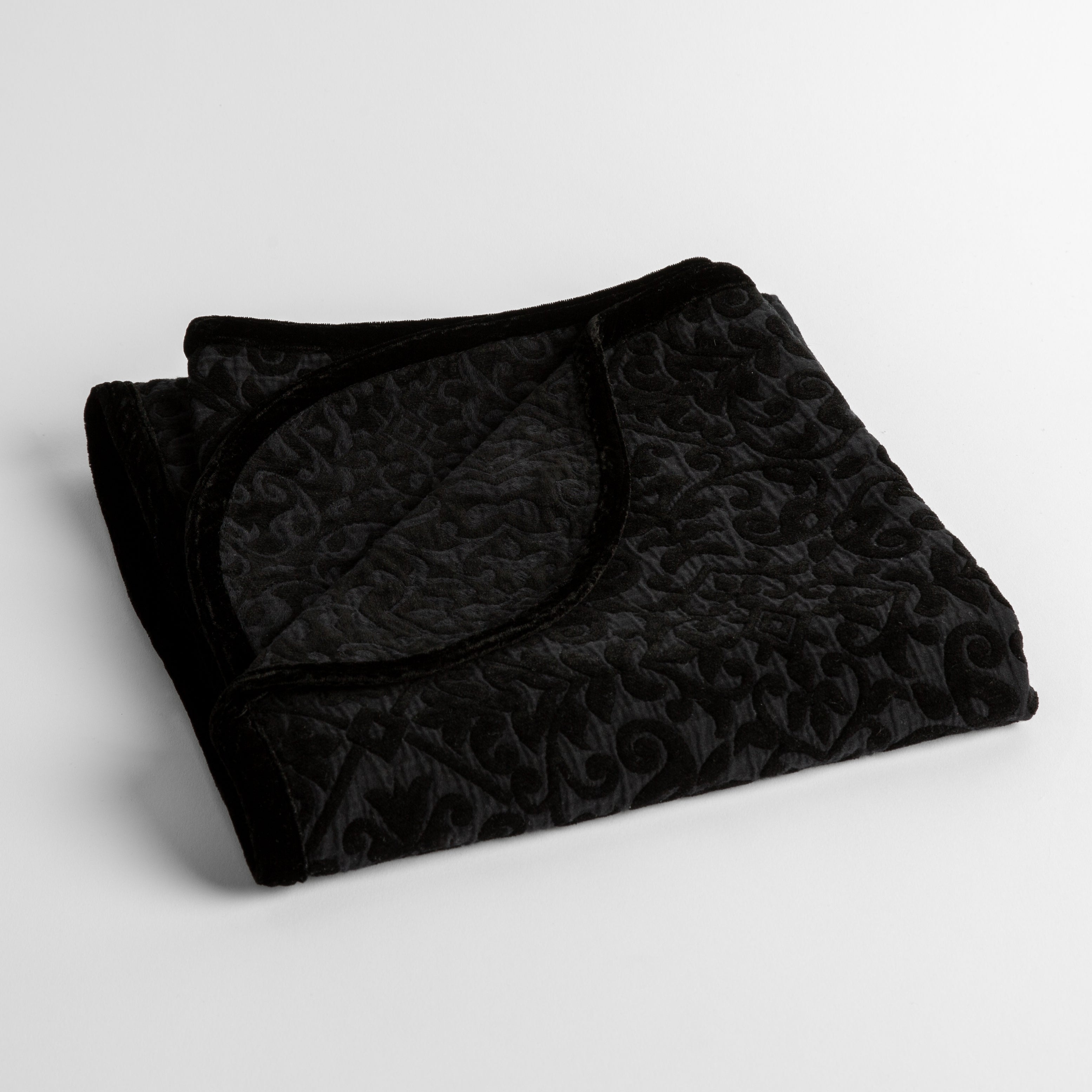 Corvino: a folded cotton chenille baby blanket trimmed in silk velvet shot overhead at a slight angle against a white background.