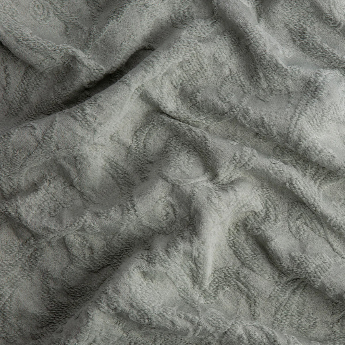 Eucalyptus: A close up of Adele fabric in eucalyptus, a soft light green. The fabric is rumpled to show the cotton damask texture.