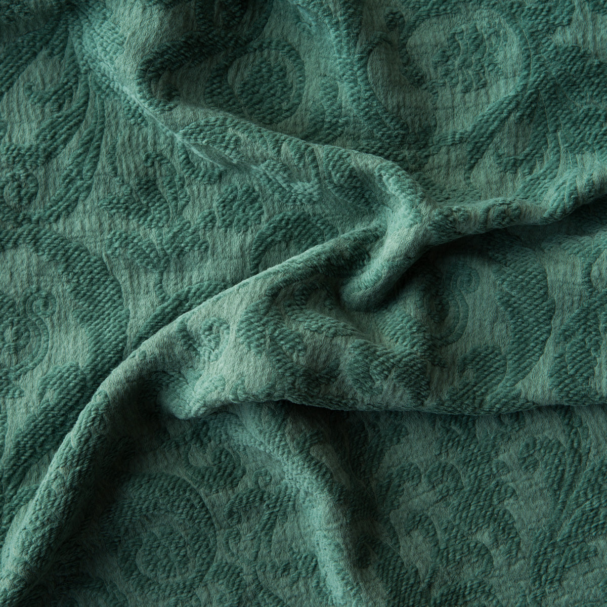 Jade: A close up of Adele fabric in jade, a rich, verdant green with subtle blue undertones. The fabric is rumpled to show the cotton damask texture.