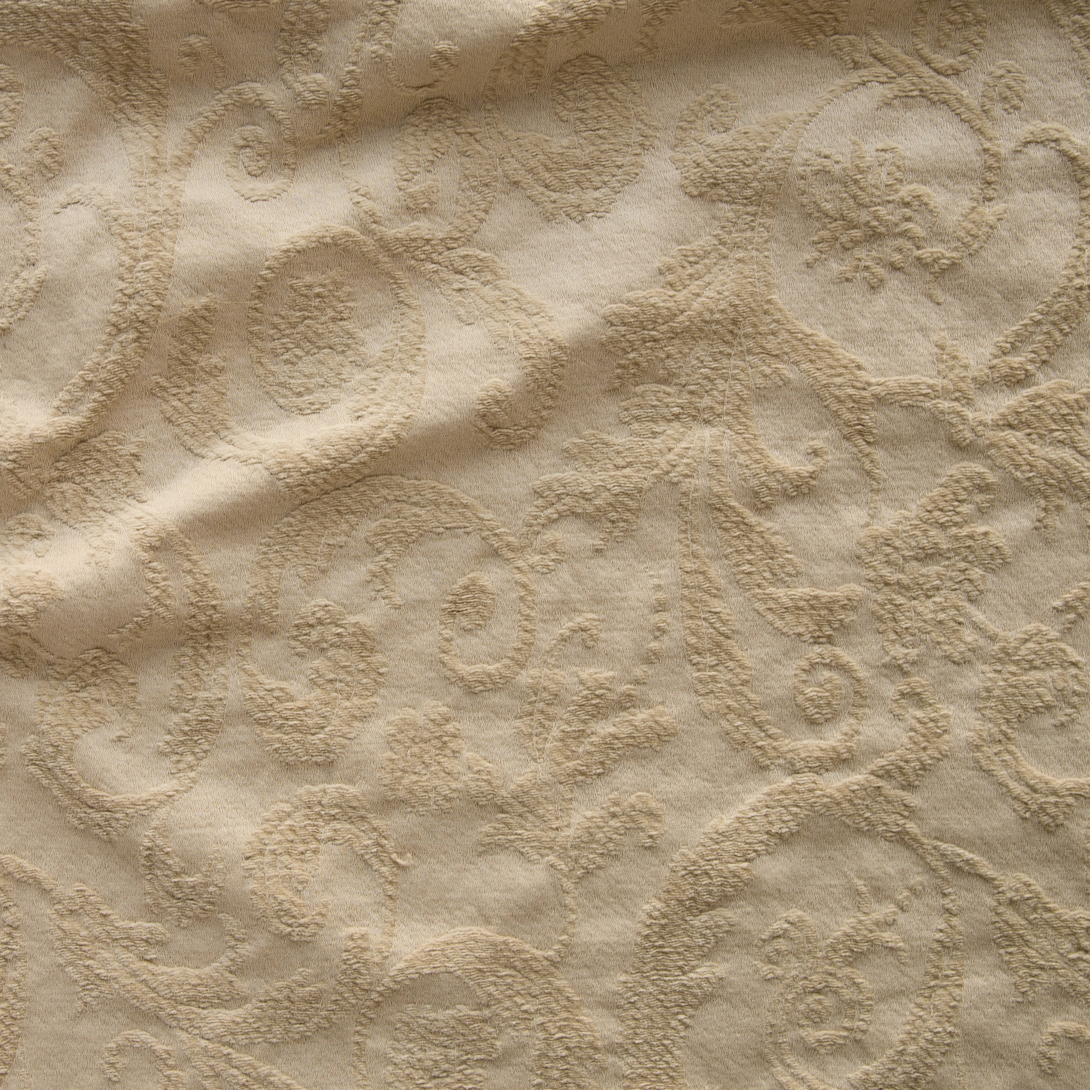 Honeycomb: A close up of Adele fabric in honeycomb, a warm golden tone. The fabric is rumpled to show the cotton damask texture.