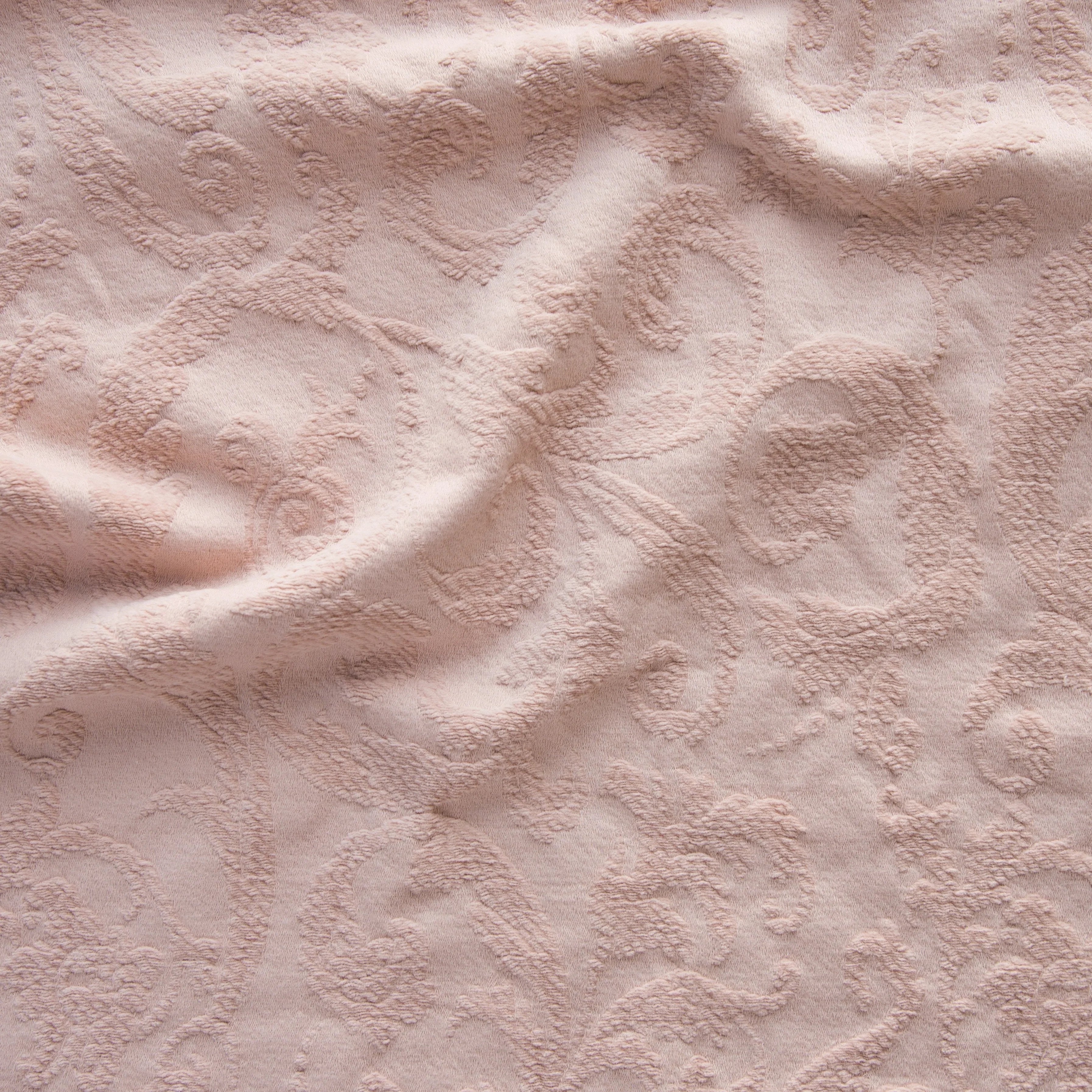 Rouge: A close up of Adele fabric in rouge, a mid-tone blush pink. The fabric is rumpled to show the cotton damask texture.