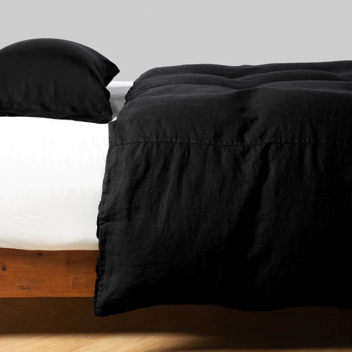 Corvino: Midweight linen duvet cover on a bed, side view.