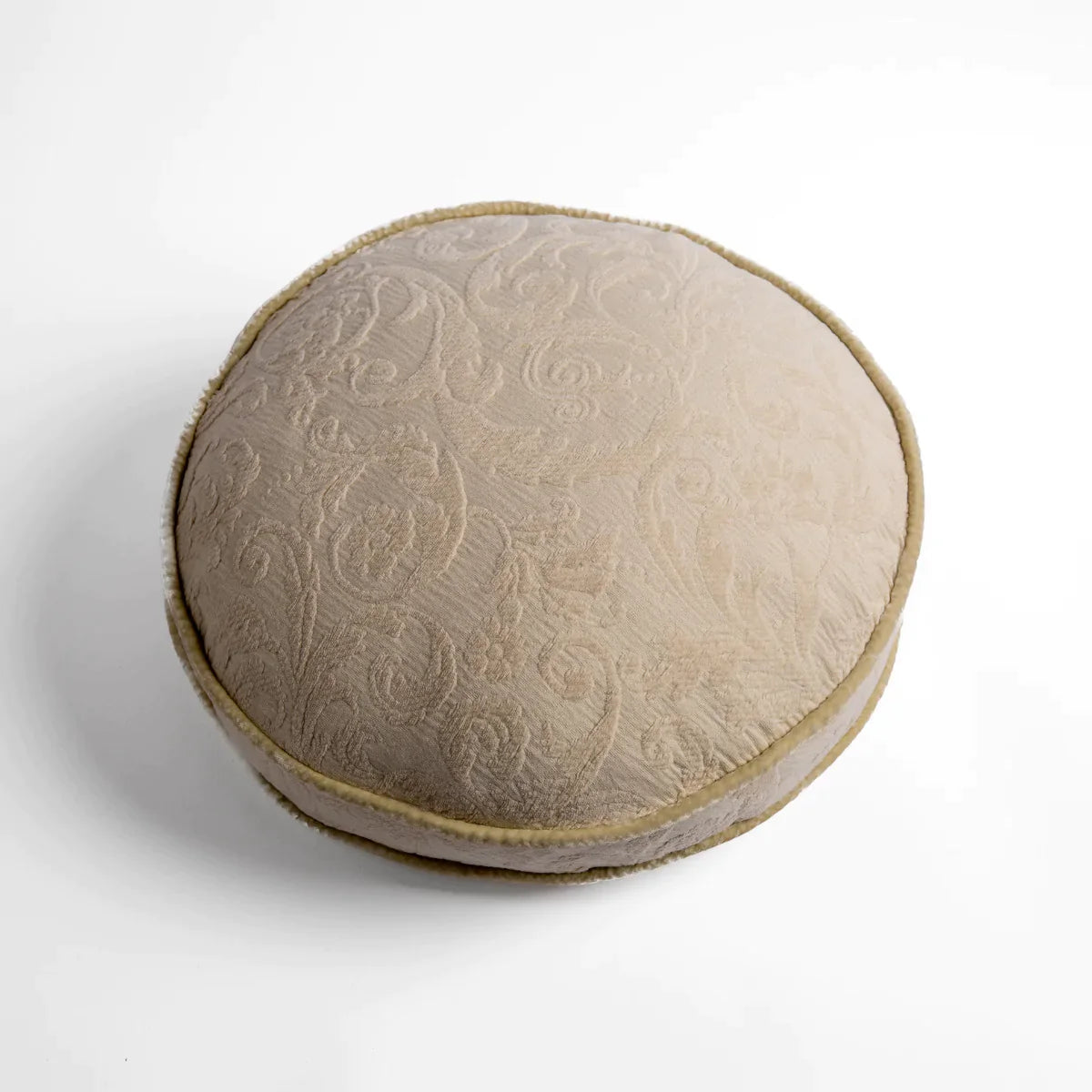 Parchment: Organic cotton damask round pillow with silk velvet trim on white background β overhead angle.
