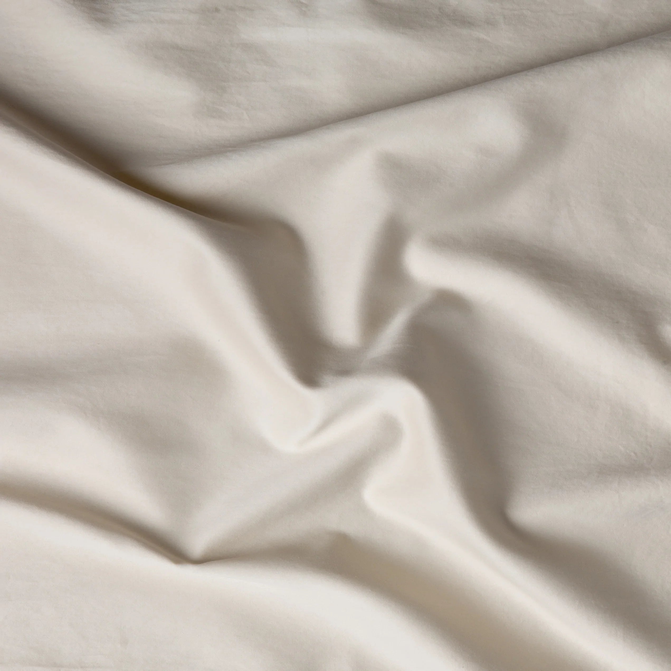 Parchment: A close up of cotton sateen fabric in parchment, a warm, antiqued cream.
