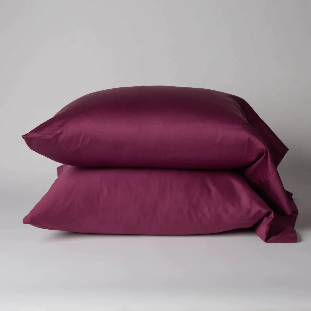 Fig: Two cotton sateen sleeping pillows, stacked neatly against a white backdrop - side view.