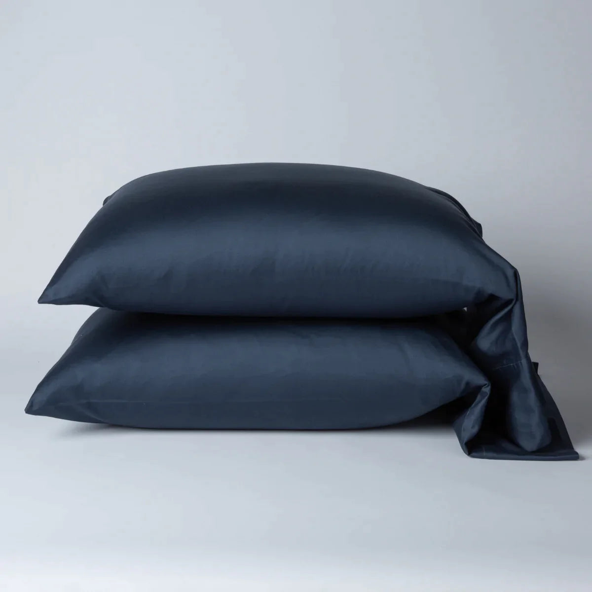 Midnight: Two cotton sateen sleeping pillows, stacked neatly against a white backdrop - side view.