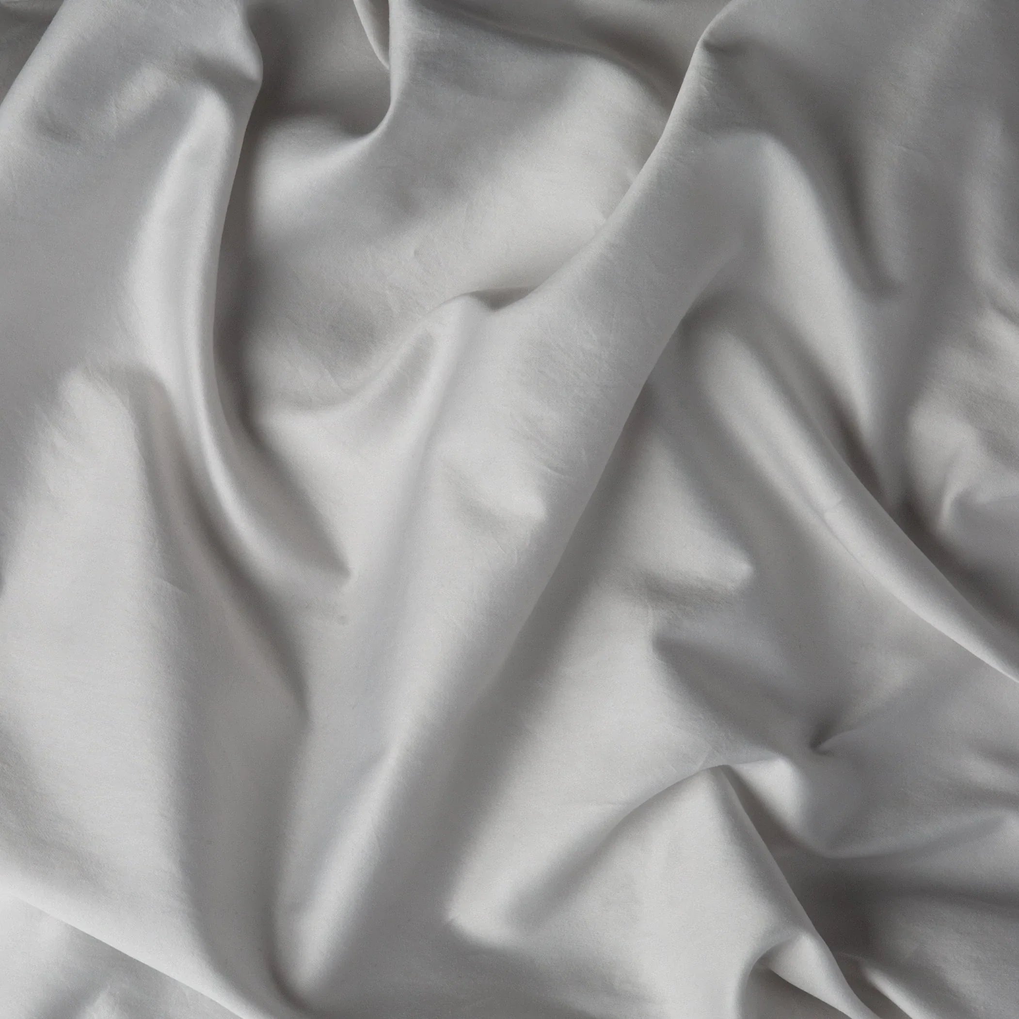 Sterling: A close up of cotton sateen fabric in sterling, a silvery neutral light grey.