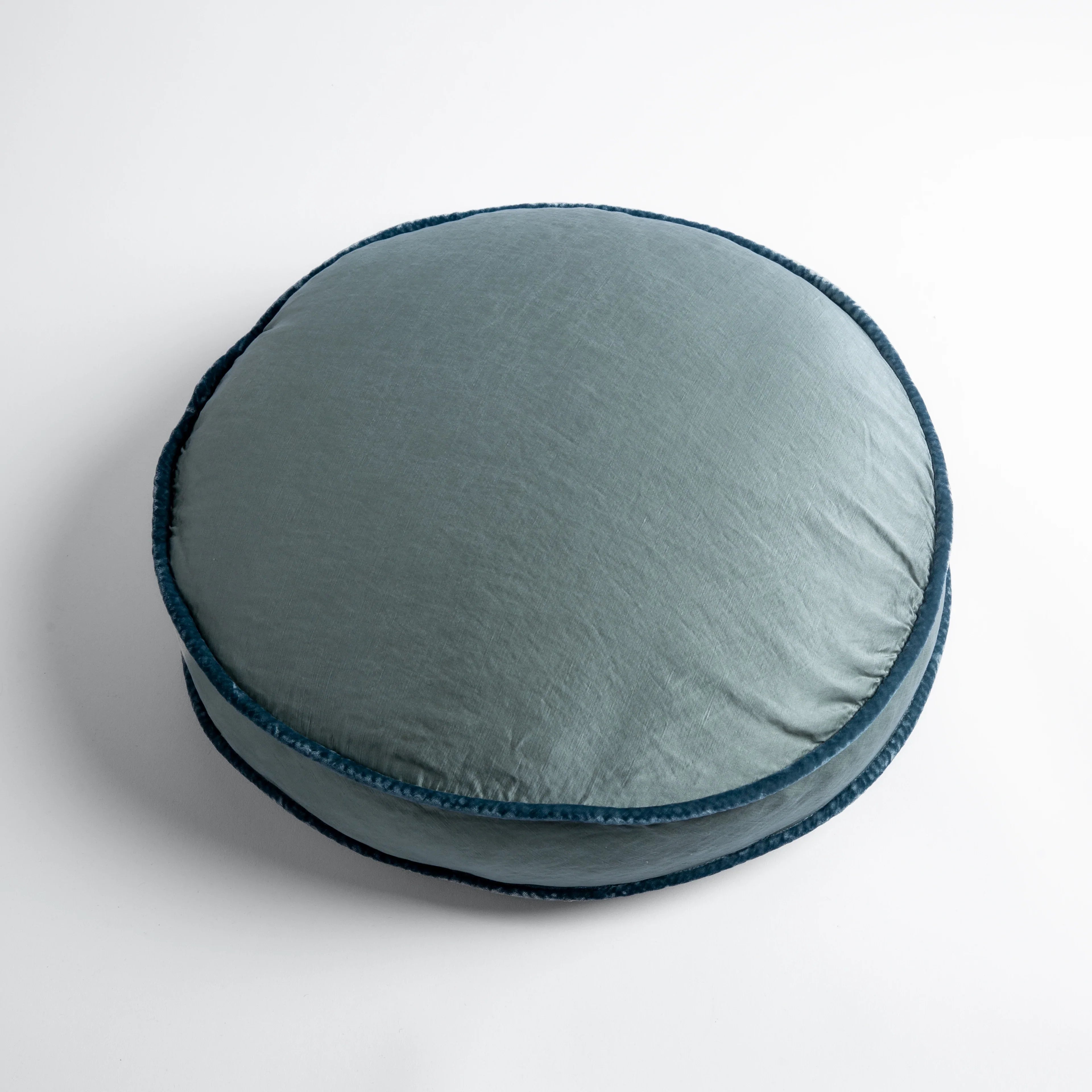 Mineral: 18" round charmeuse pillow with silk velvet trim at gusset shot from overhead on a white background