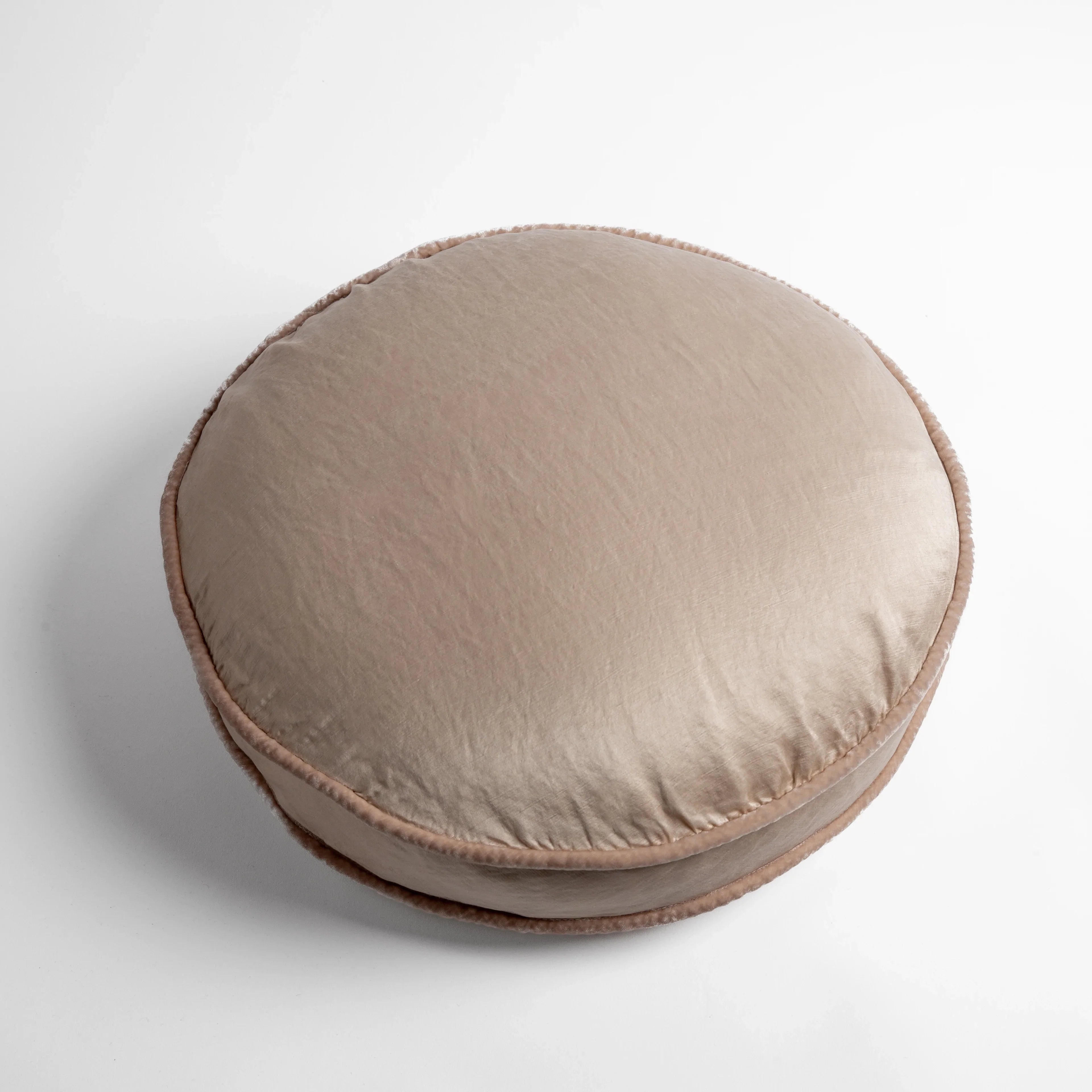 Pearl: 18" round charmeuse pillow with silk velvet trim at gusset shot from overhead on a white background