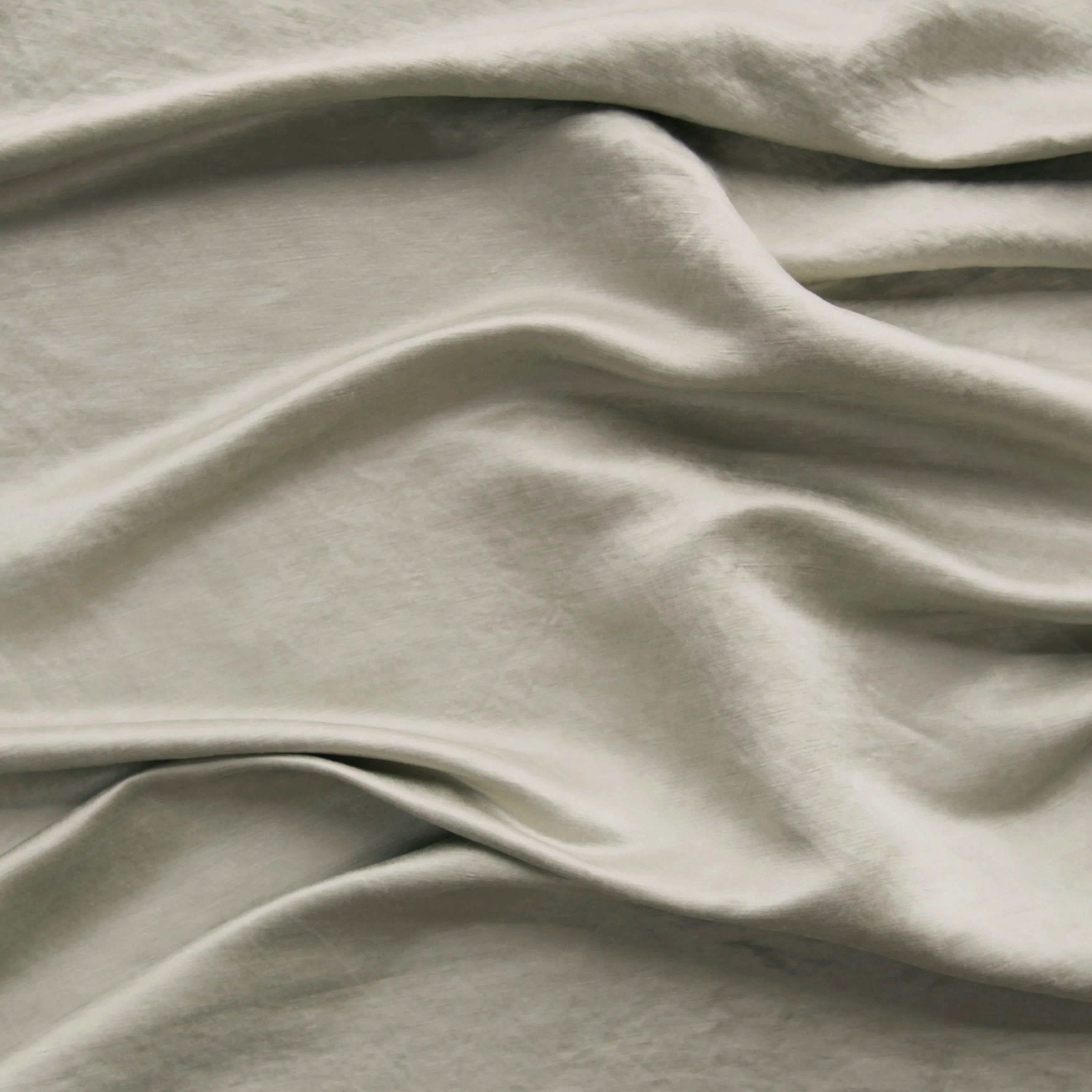 Fog: Close-up of silk charmeuse in fog, a neutral-warm, soft mid-tone grey.