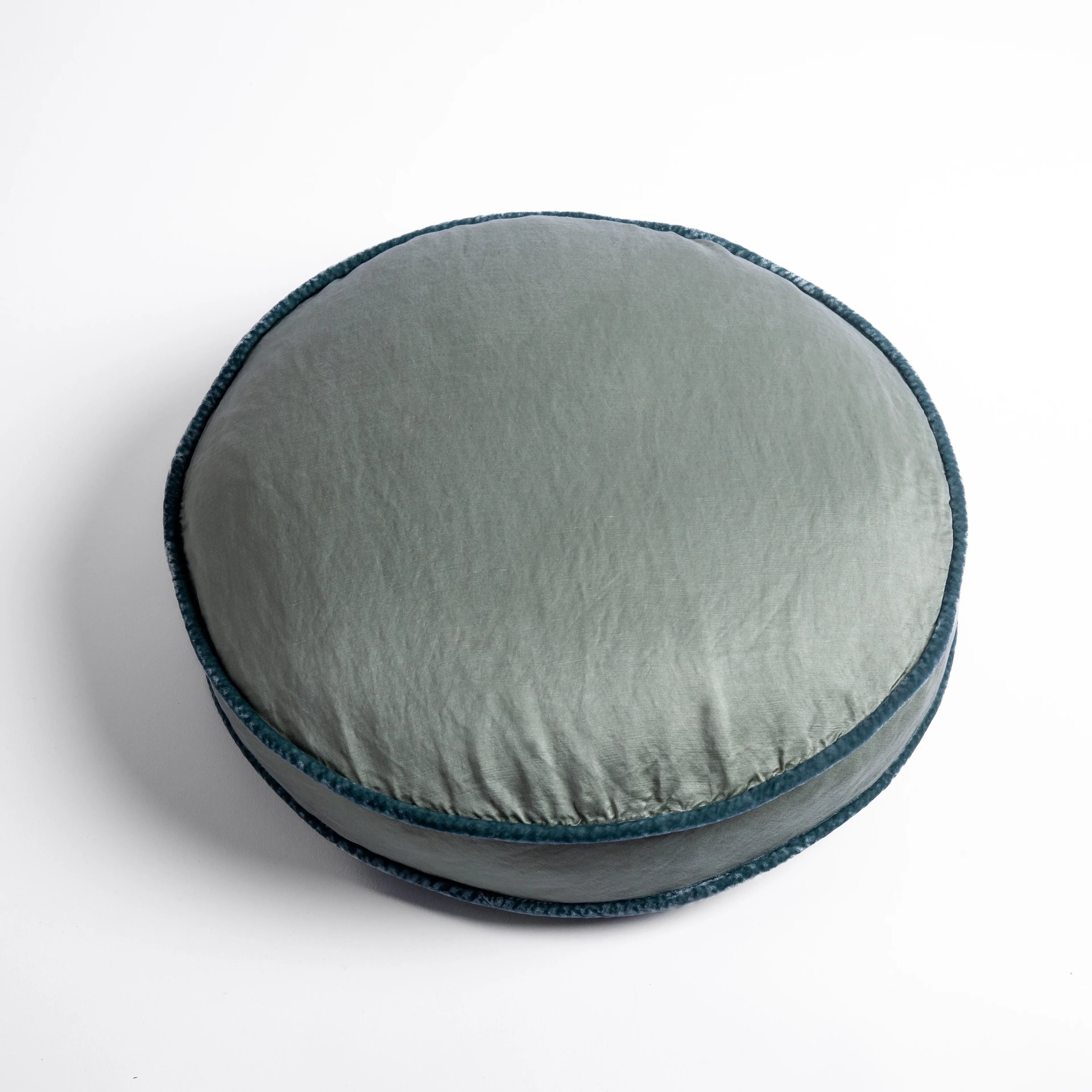 Eucalyptus: 18" round charmeuse pillow with silk velvet trim at gusset shot from overhead on a white background