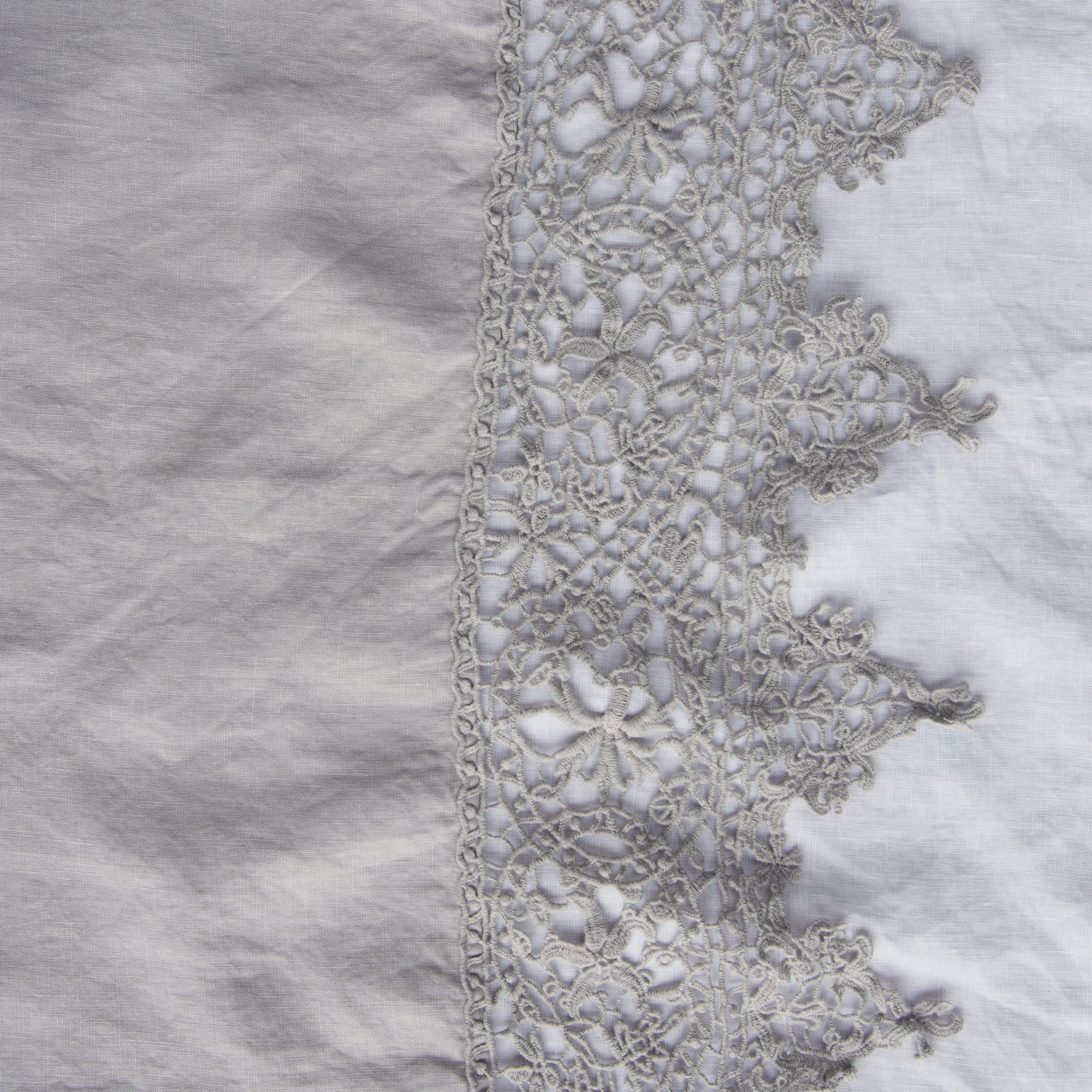 Fog: A close up of Frida, an antique cotton lace trim on a linen body, shown in fog, a neutral-warm, soft mid-tone grey.
