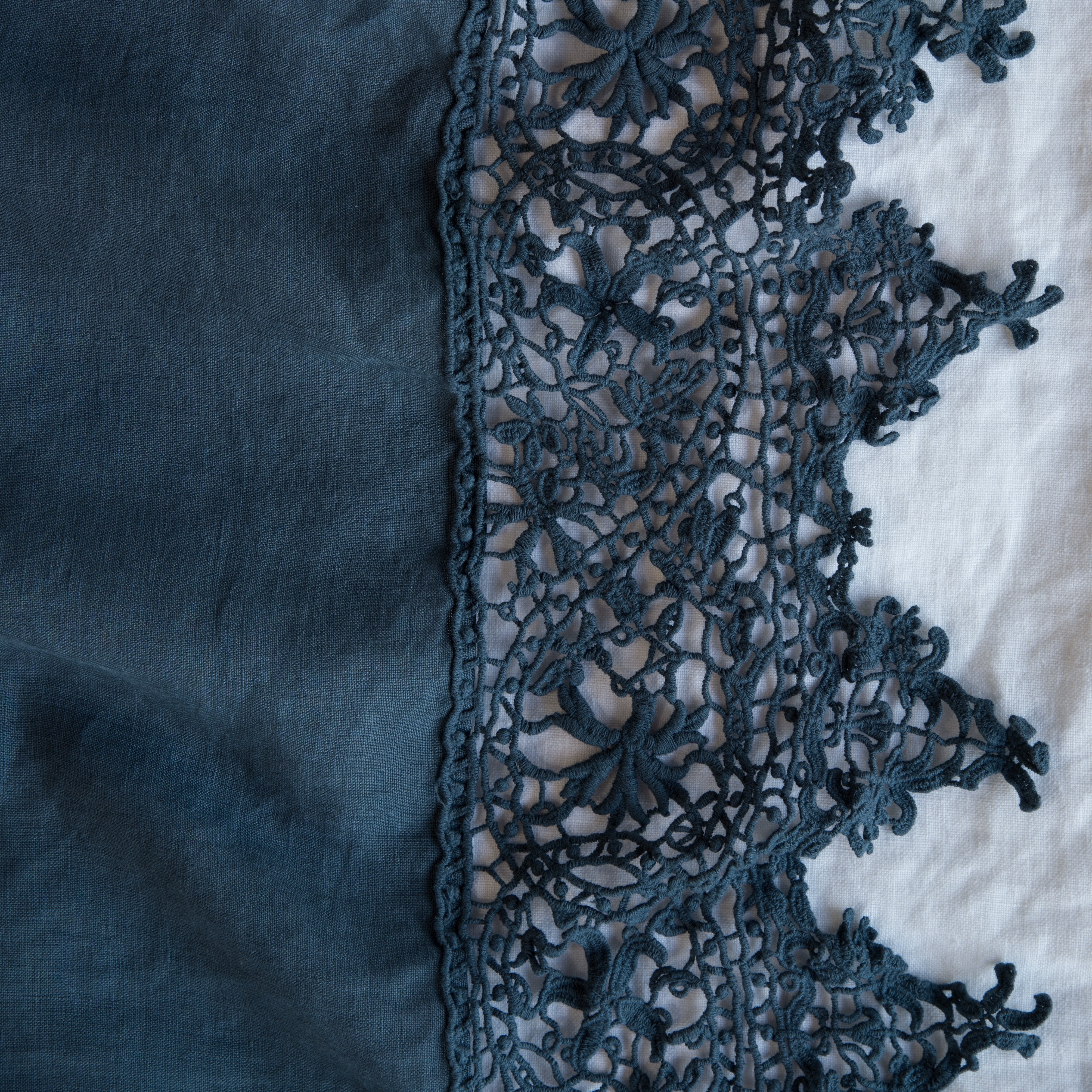 Midnight: A close up of Frida, an antique cotton lace trim on a linen body, shown in midnight, a rich indigo tone.