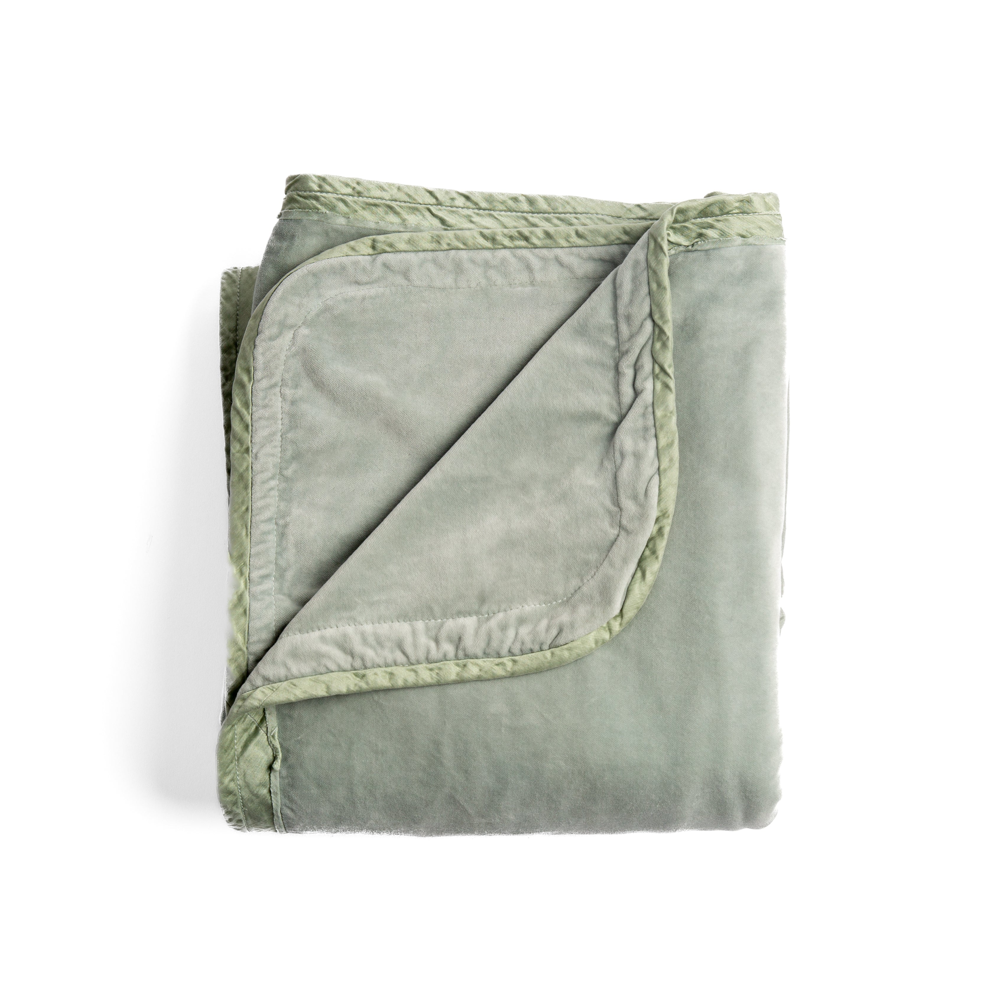 Eucalyptus: overhead angle of the folded blanket with a corner pulled back to show the reverse and trim.