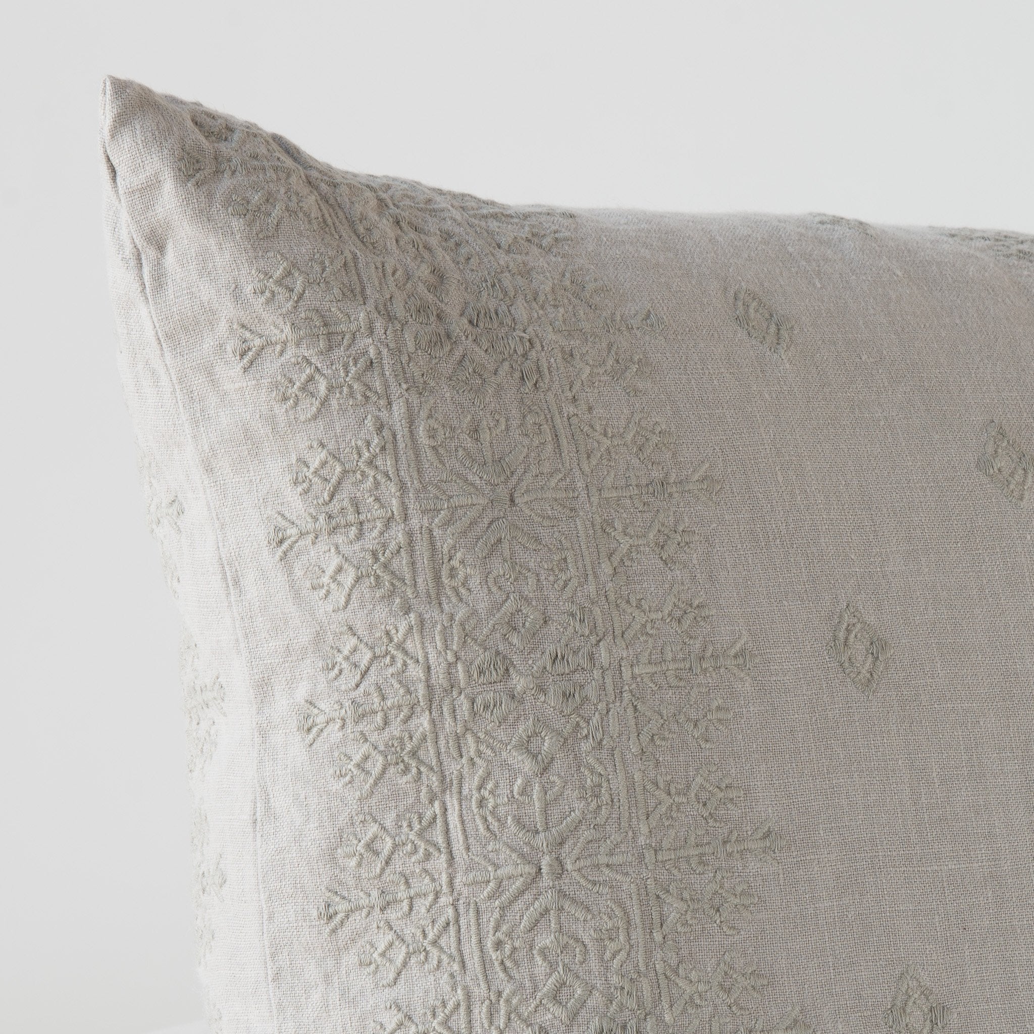 Fog: Close-up of pillow corner, showcasing the embroidery pattern detail.