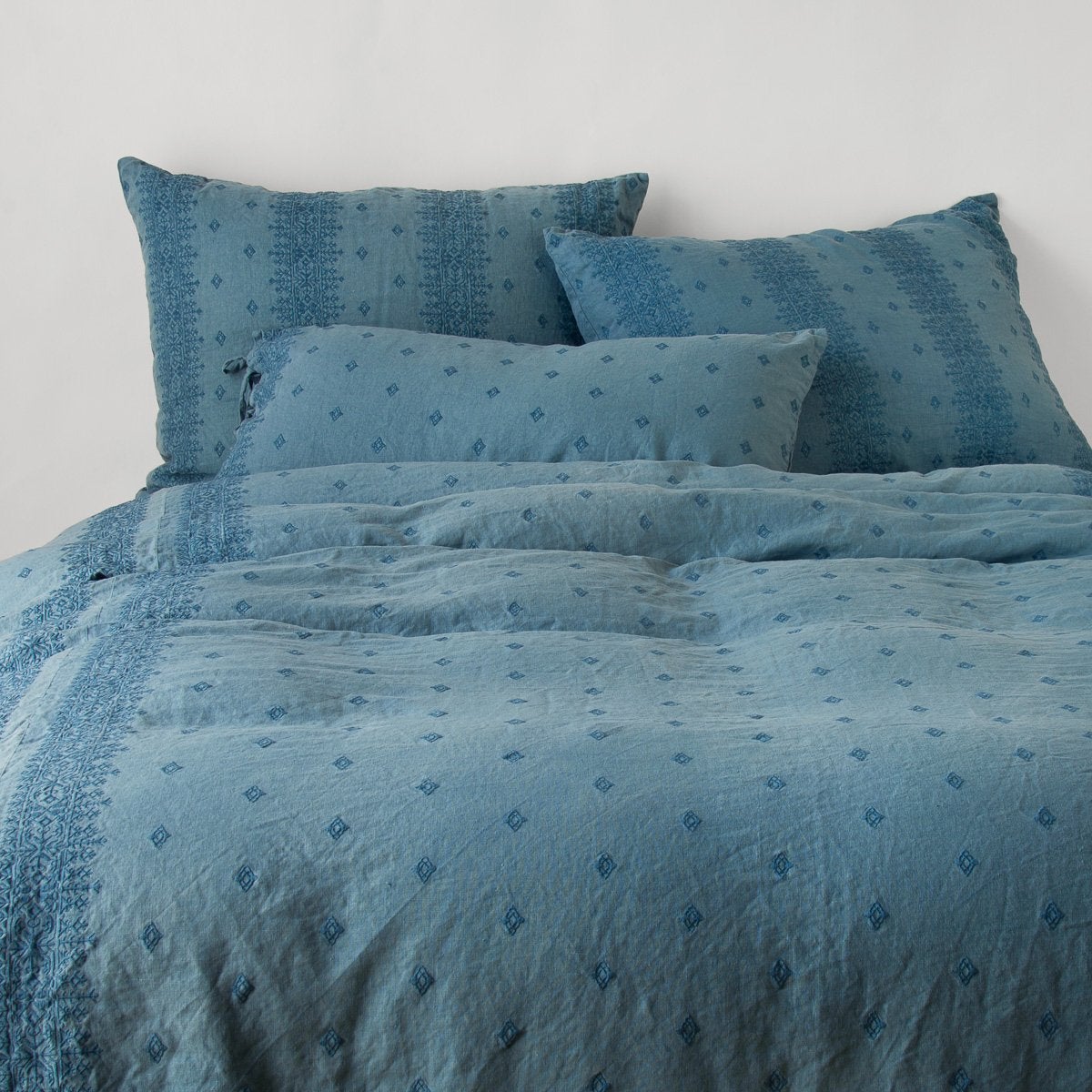 Cenote: duvet cover and matching shams against a white wall - end of bed view.