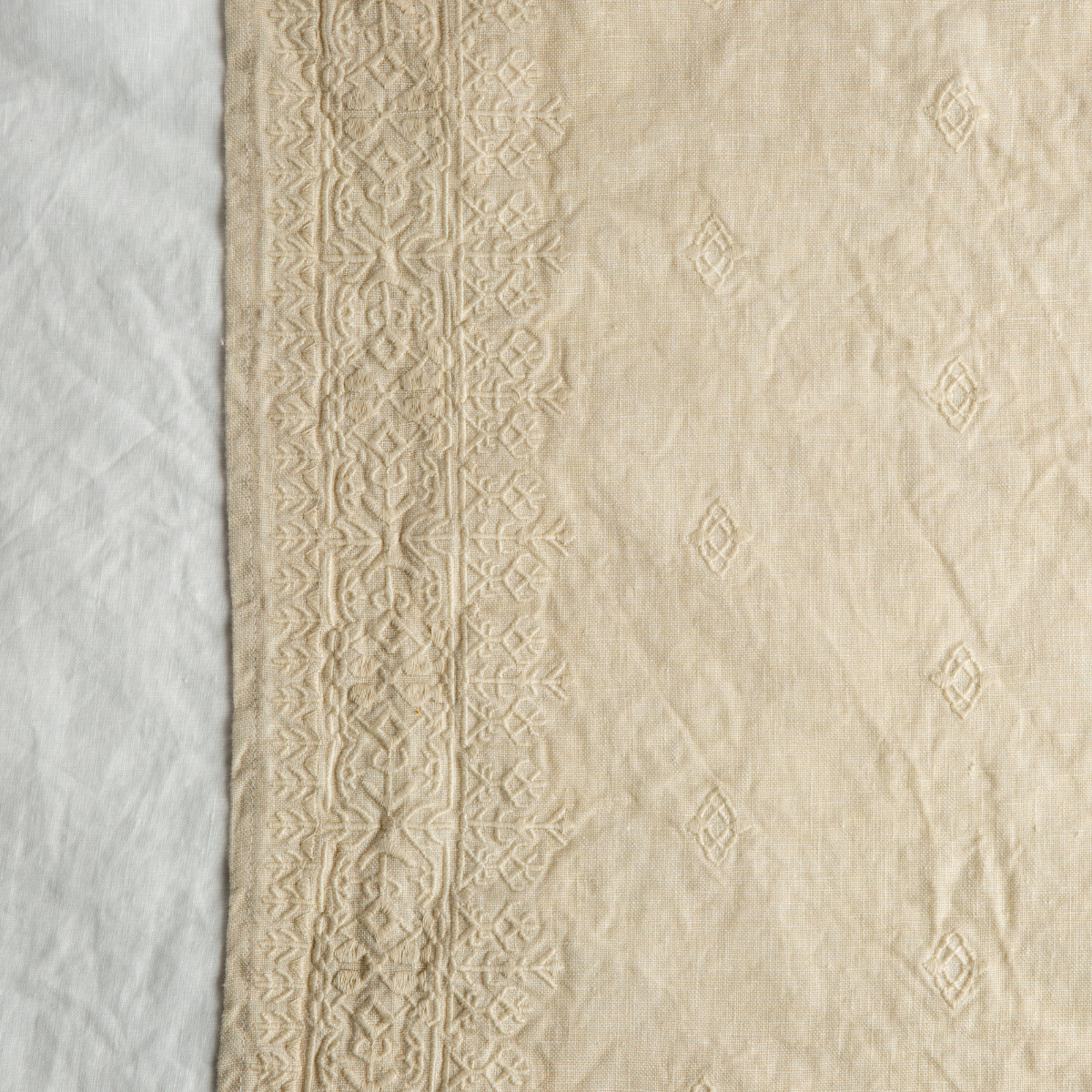 Parchment: A close up of Ines, midweight linen with cotton embroidery, in parchment, a warm, antiqued cream.