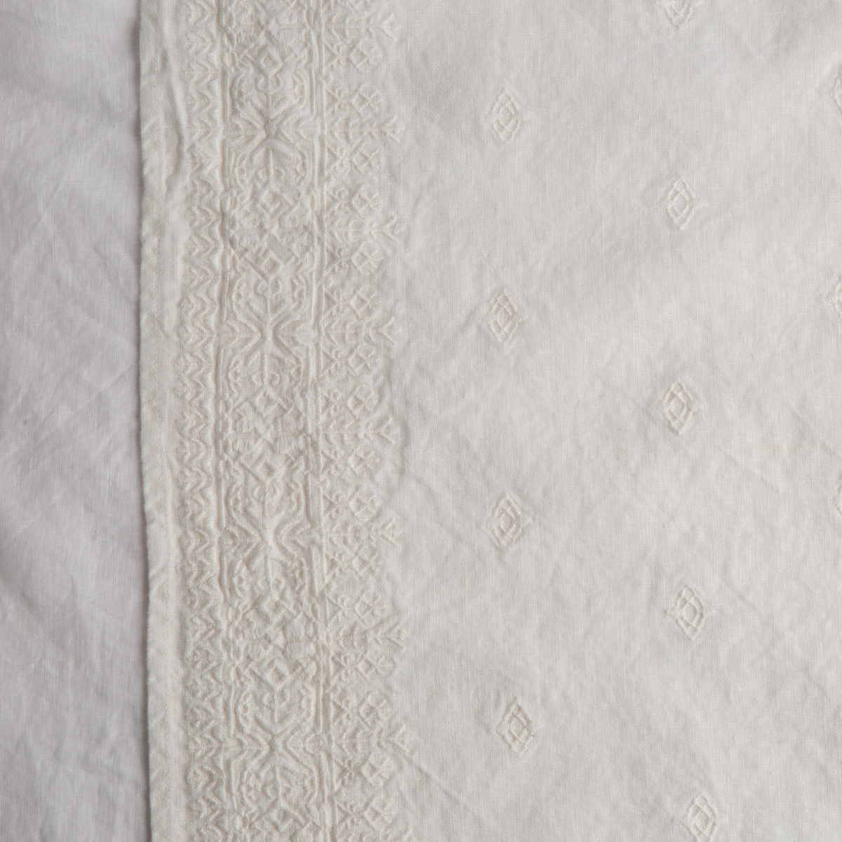 Winter White: A close up of Ines, midweight linen with cotton embroidery, in white.