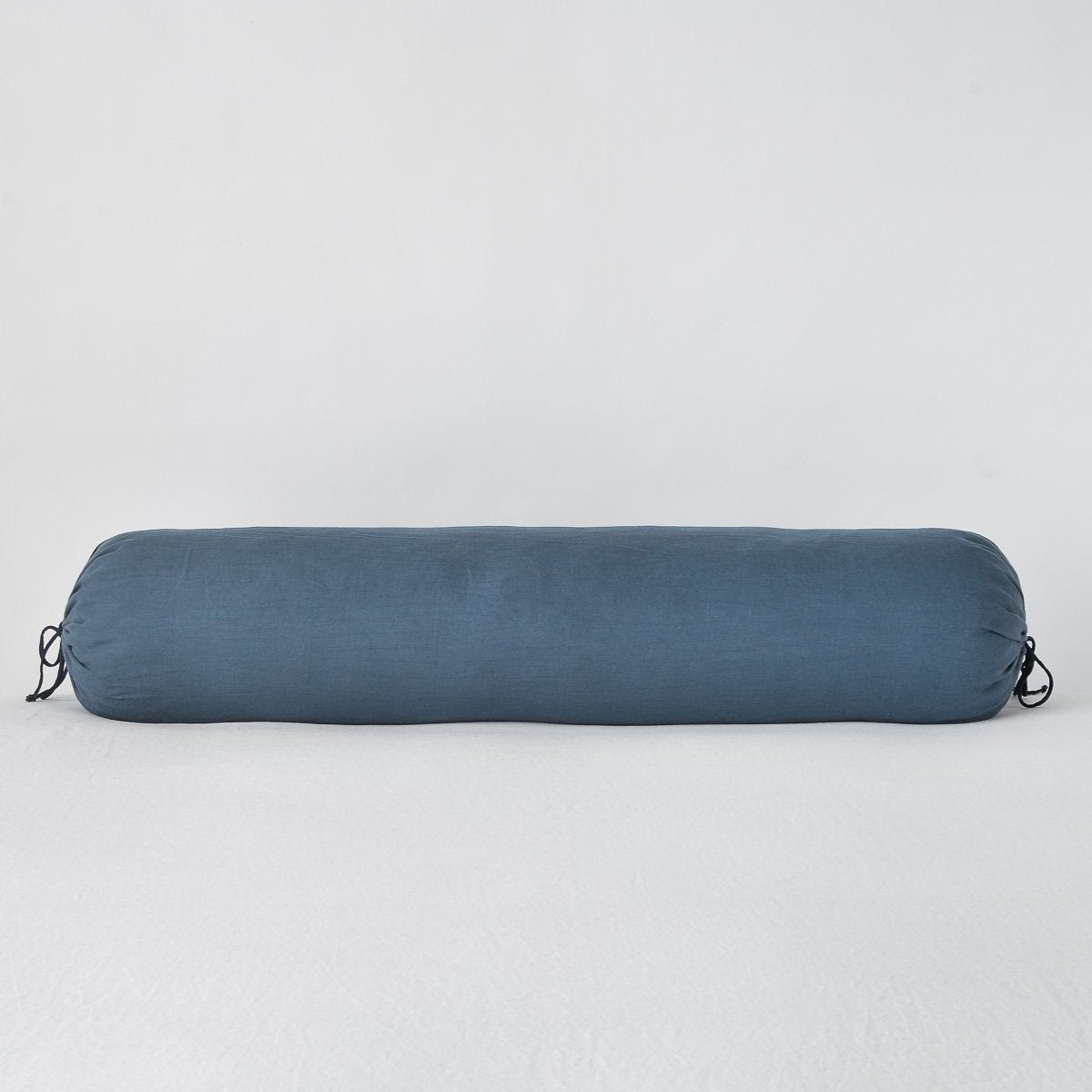 Midnight: Linen bolster in midnight against a plain background.
