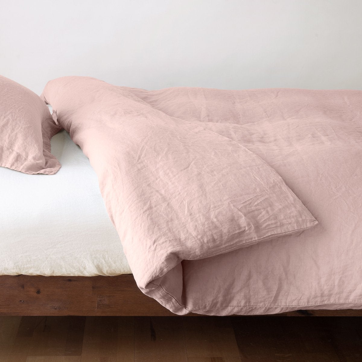 Rouge: duvet cover neatly folded back over white linen sheeting - side view.
