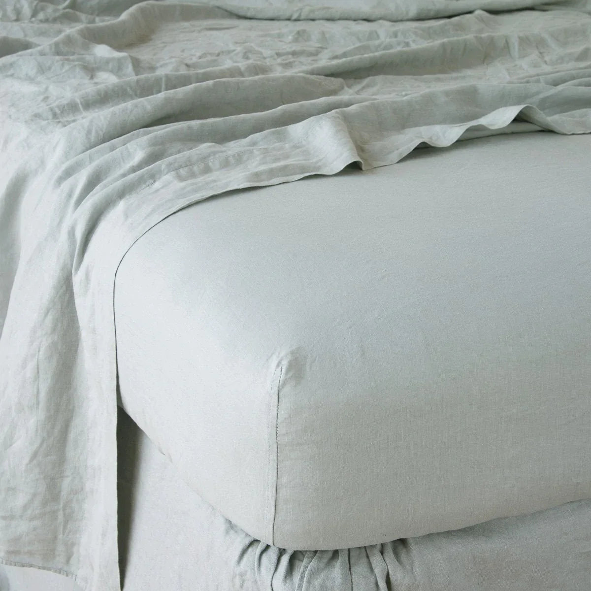 Eucalyptus: close up of fitted sheet with matching rumpled flat sheet - corner view.