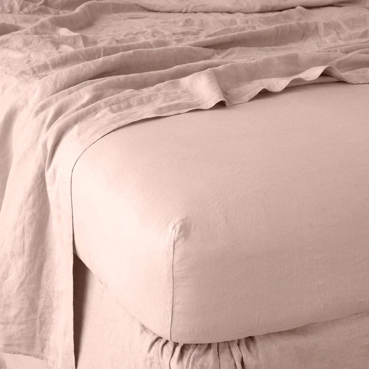 Rouge: close up of fitted sheet with matching rumpled flat sheet - corner view.