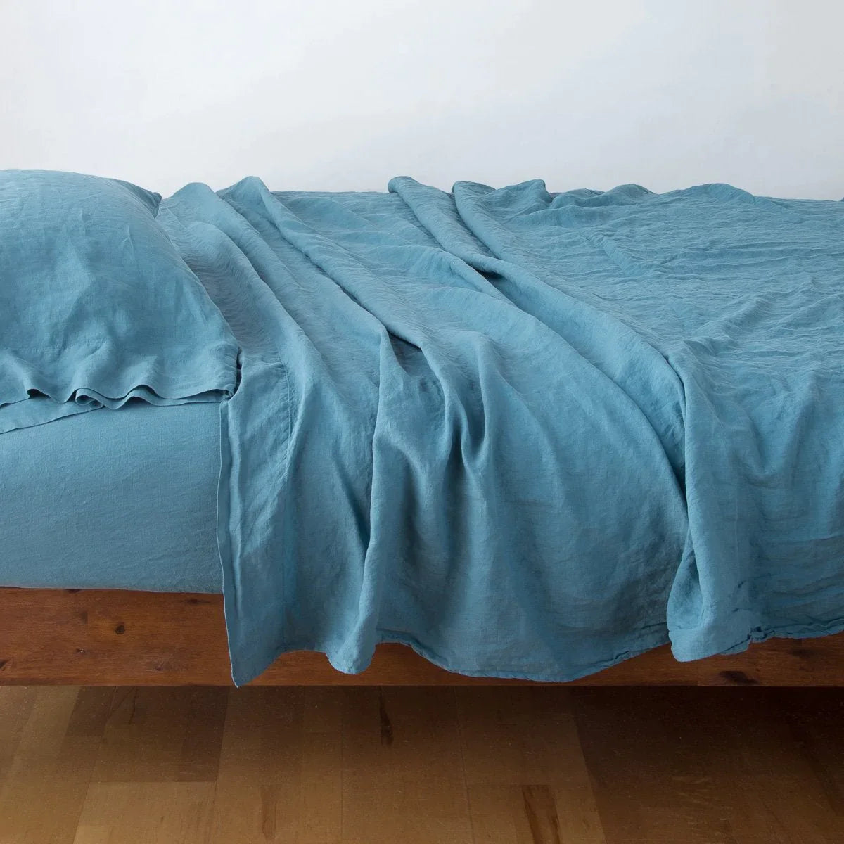 Cenote: Rumpled linen sheeting with matching sleeping pillow - side view.