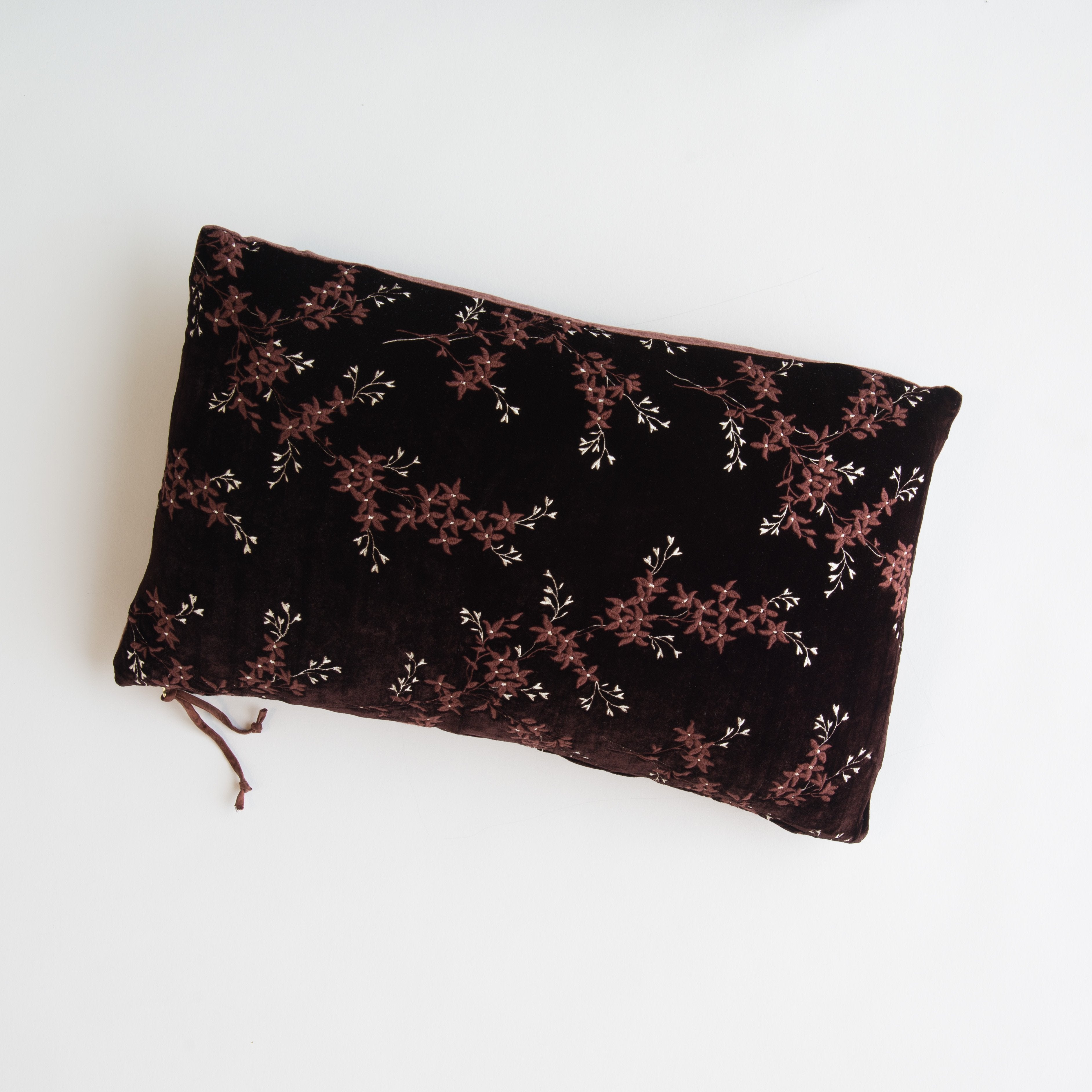 Mahogany: overhead of 15x24 embroidered silk velvet pillow against a white background