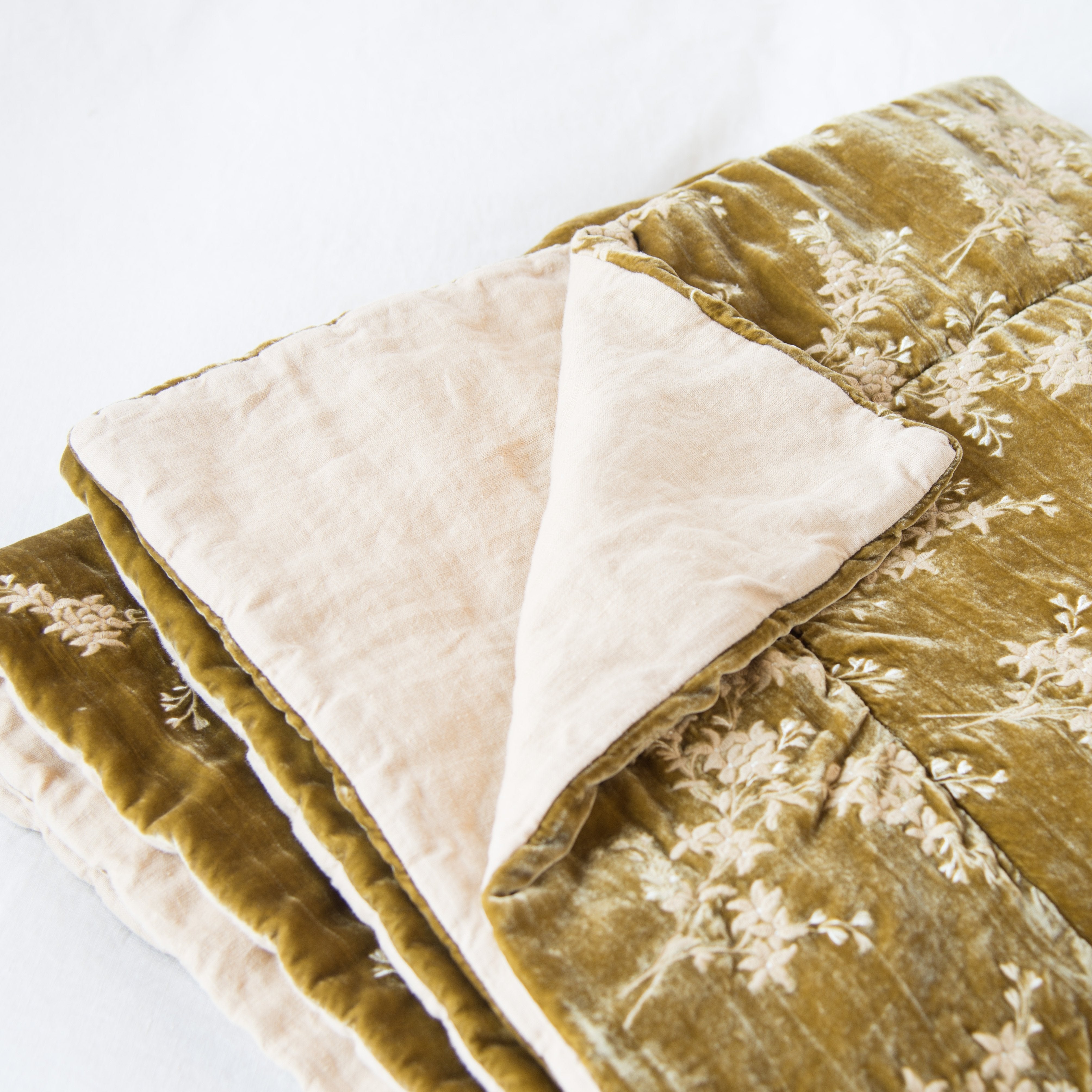 : Lynette throw blanket in honeycomb, neatly folded on a light background, with a corner turned back to showcase the linen back - slight overhead angle.