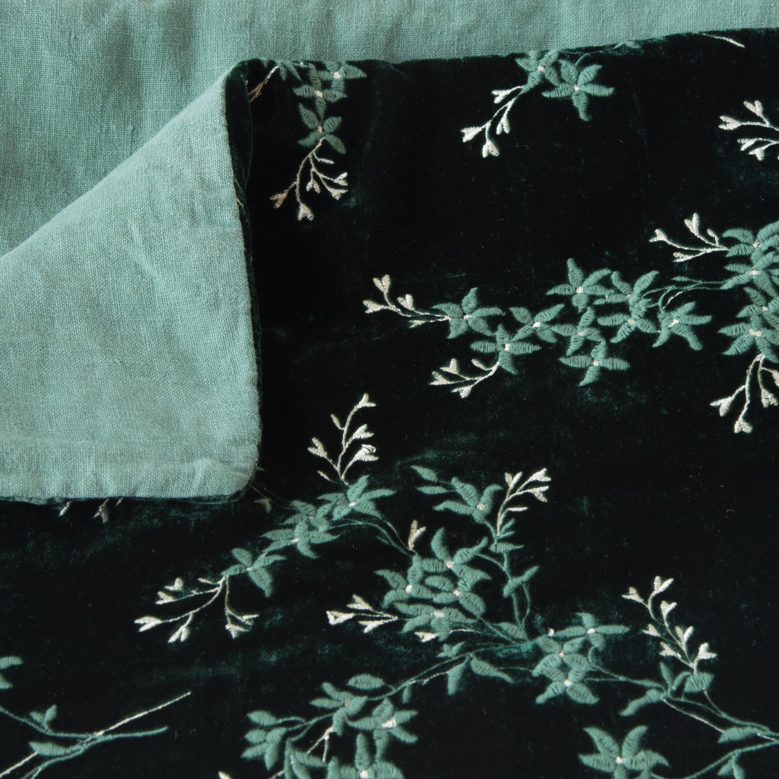 Jade: Close up of blanket, with a corner turned back to showcase the linen back - overhead view.