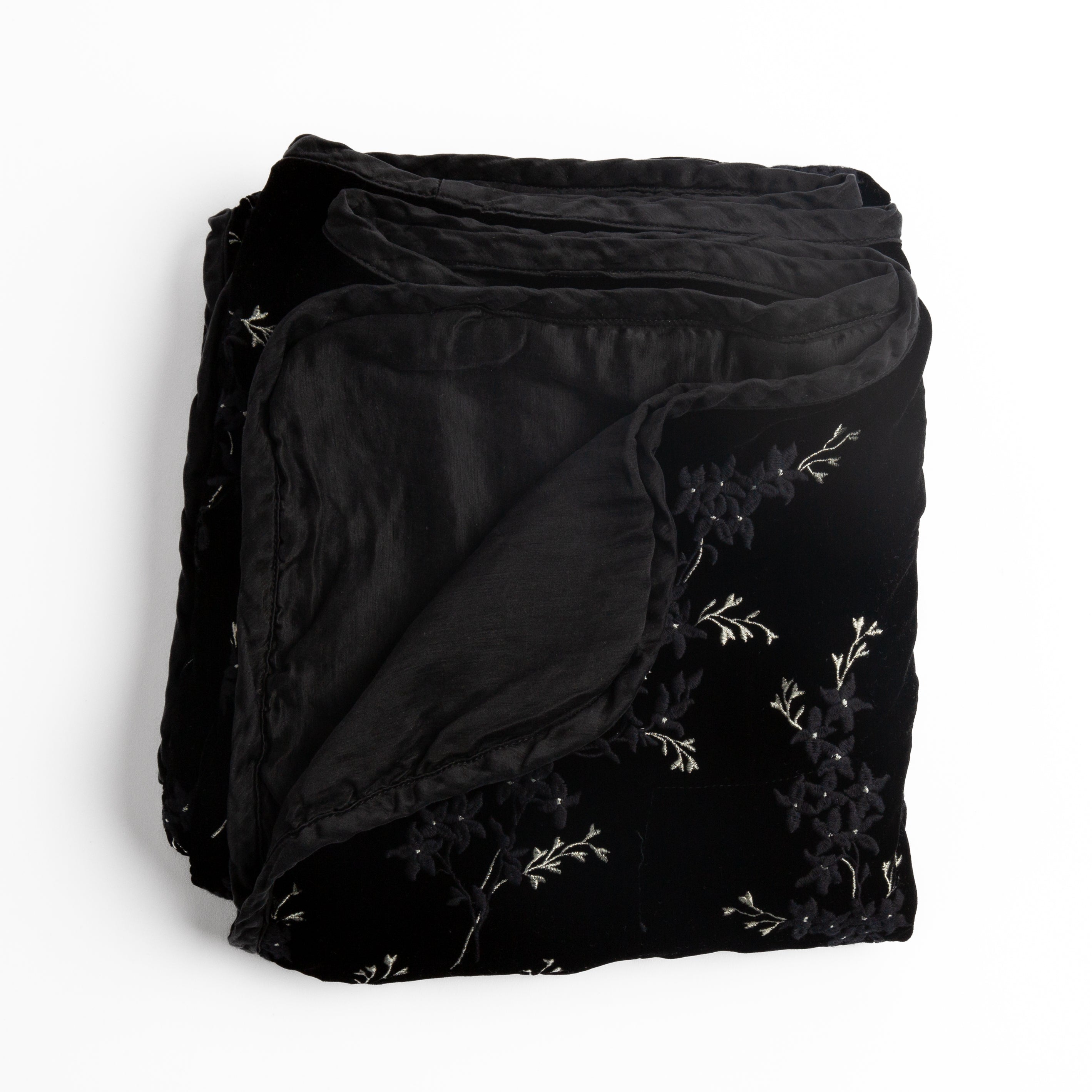 Corvino: overhead angle of the folded blanket with a corner pulled back to show the reverse and trim.