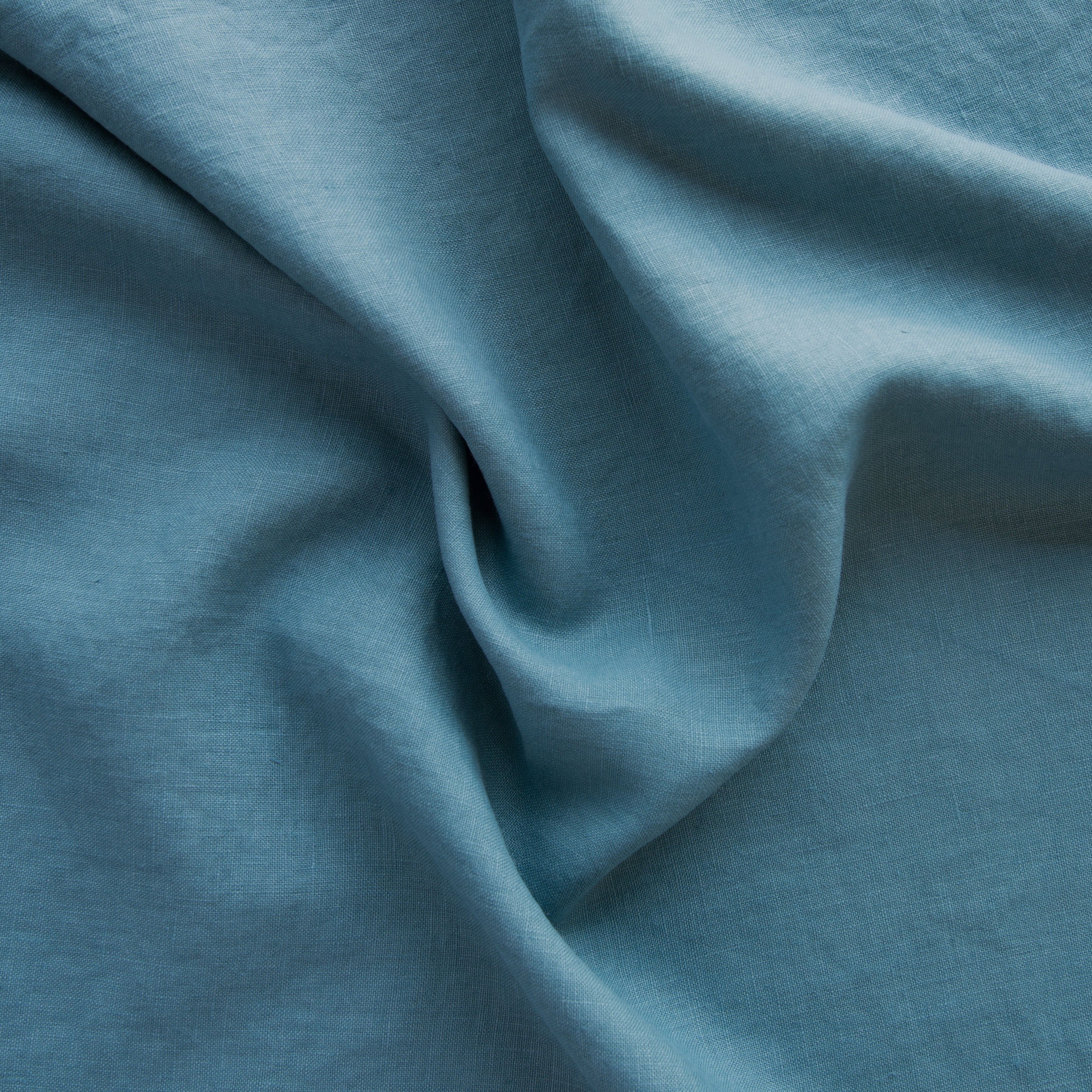 Cenote: A close up of midweight linen in cenote, a vibrant, ocean-inspired blue-green.
