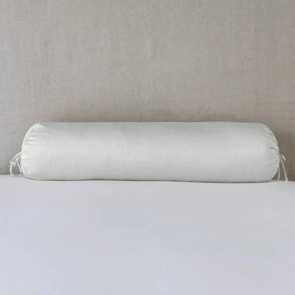 Sterling: bolster on white sheets with a neutral headboard.