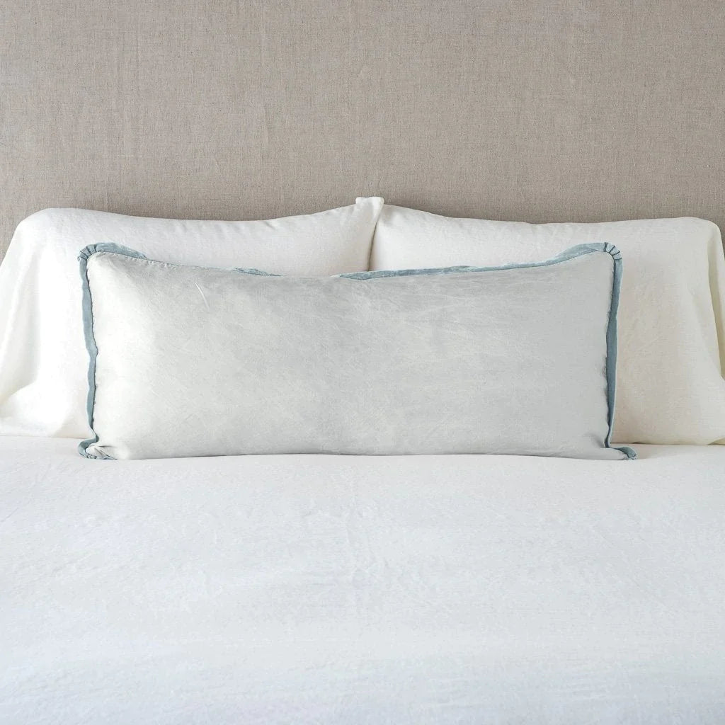 Cloud: 16x36 charmeuse pllow wth silk velvet trim against white sleeping pillows and sheets — straight on with neutral background.