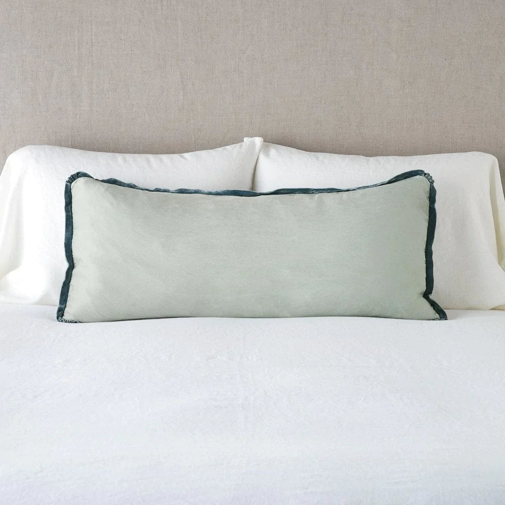 Eucalyptus: 16x36 charmeuse pllow wth silk velvet trim against white sleeping pillows and sheets — straight on with neutral background.